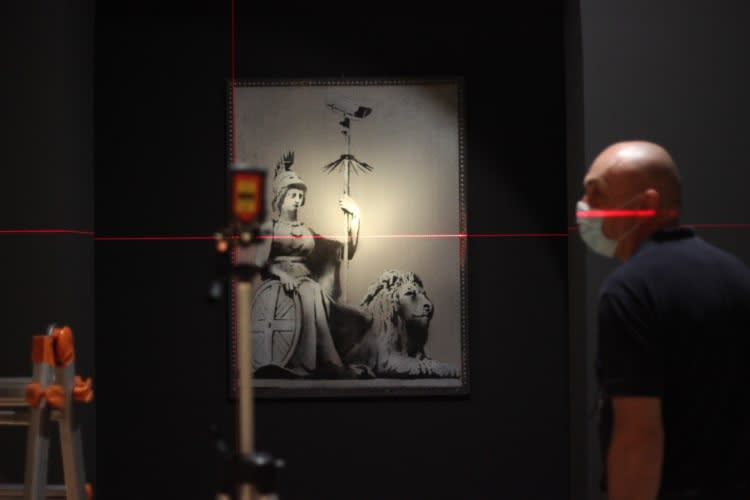 Banksy artwork hanging on wall