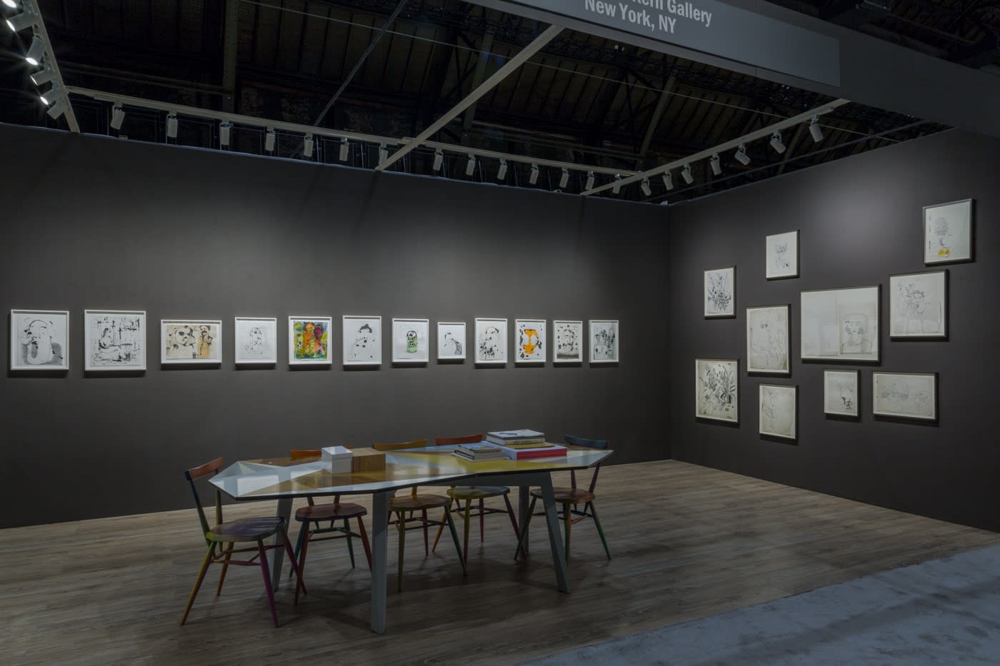 Nicole Eisenman and Andy Warhol dual booth at ADAA. Dark walls populated with drawings by the two artists.