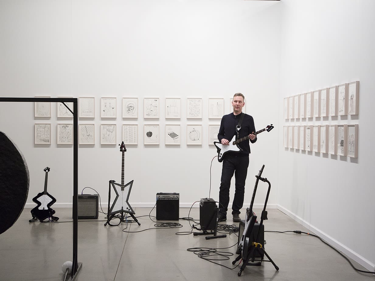 David Shrigley solo booth at the Independent Art Fair, with drums, a gong, and drawings.