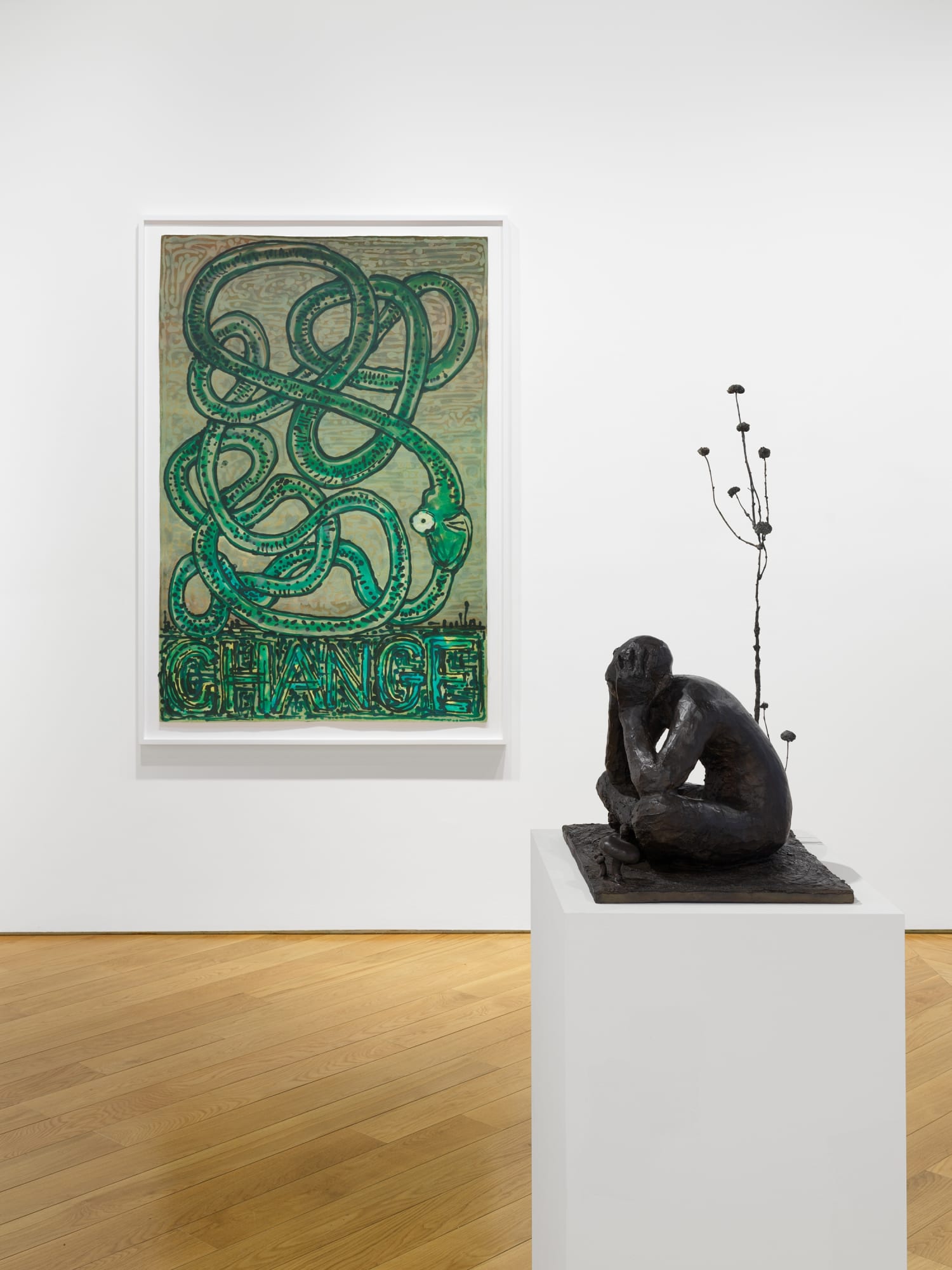 Installation view of Nicole Eisenman's exhibition at the gallery in early 2021 of maquettes and prints. Here, a pulp drawing of an entangled green snake sets the background for a lounging maquette.