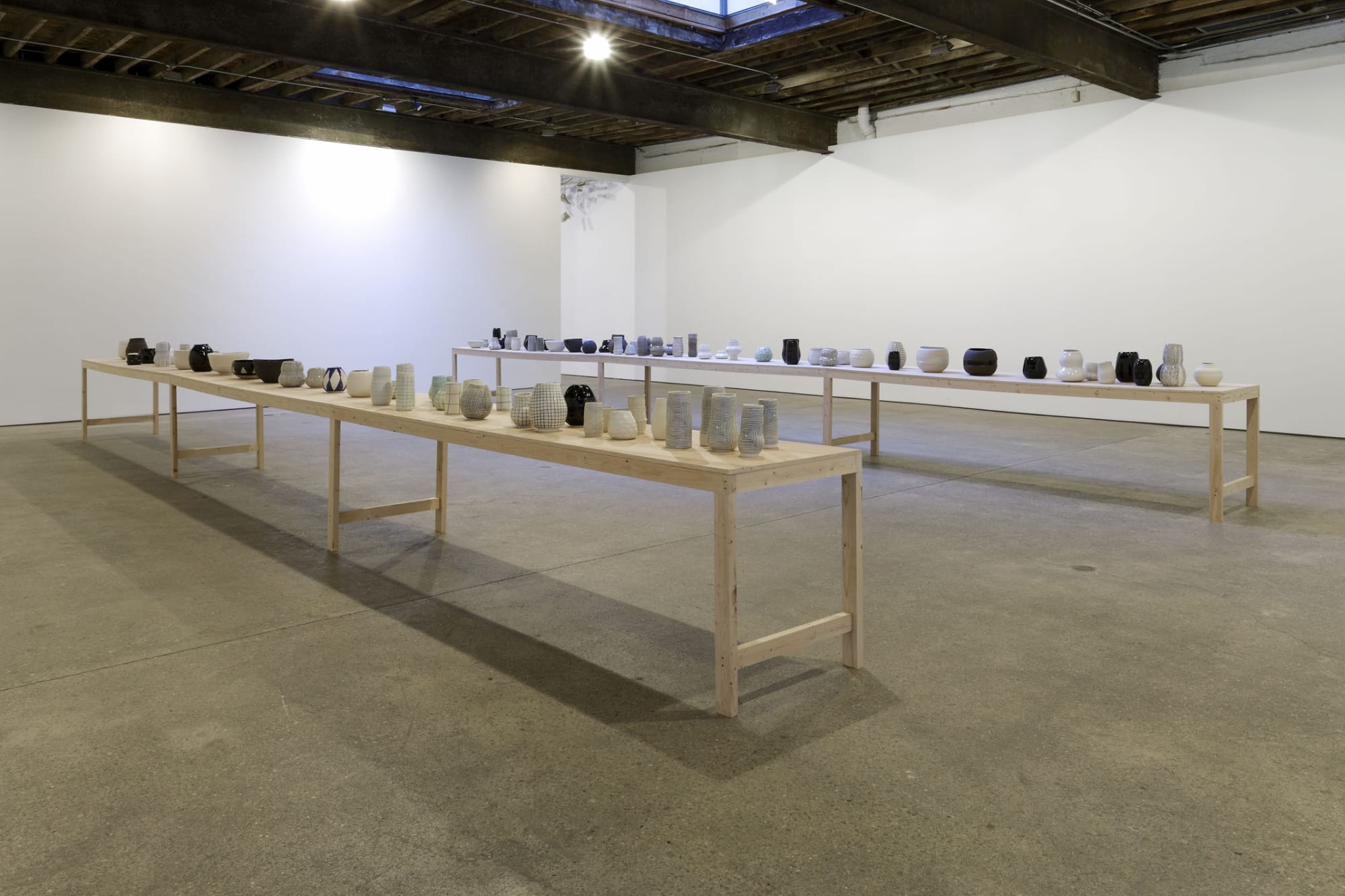 Installation view of Shio Kusaka's first solo show at Anton Kern Gallery, featuring over 100 porcelain and stoneware pots. View of the pots.