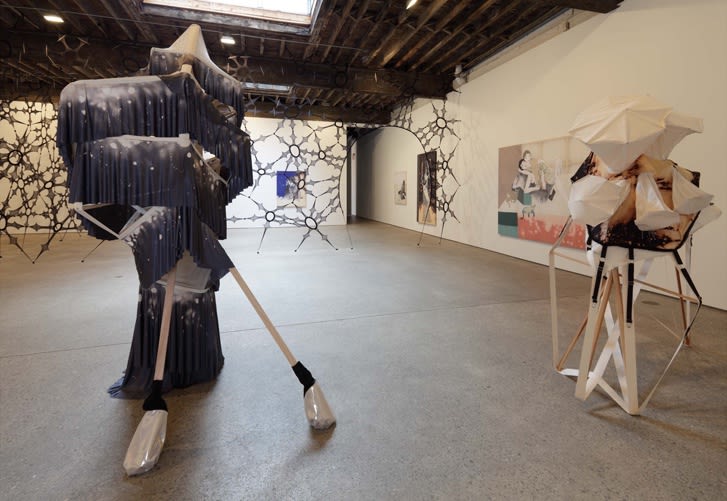 Installation view of Lara Schnitger's fifth solo show at Anton Kern Gallery, featuring two sculptures and a dozen textile paintings. The back of both sculptures.