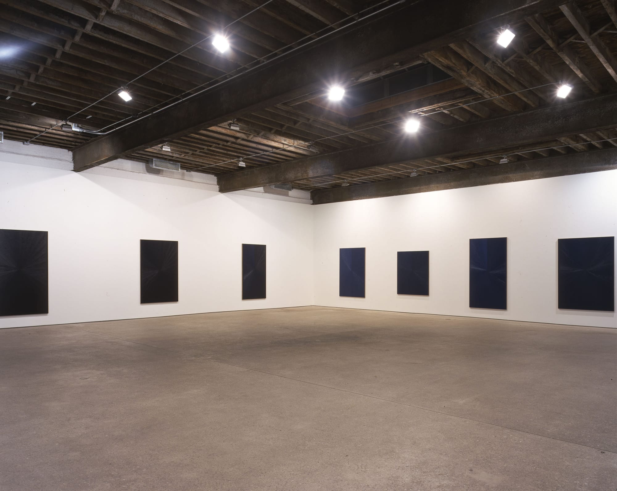 Installation view of Mark Grotjahn's second show at Anton Kern, featuring ten blue paintings descending (or ascending) in tones, shades, dynamics of blues. A few works featured.