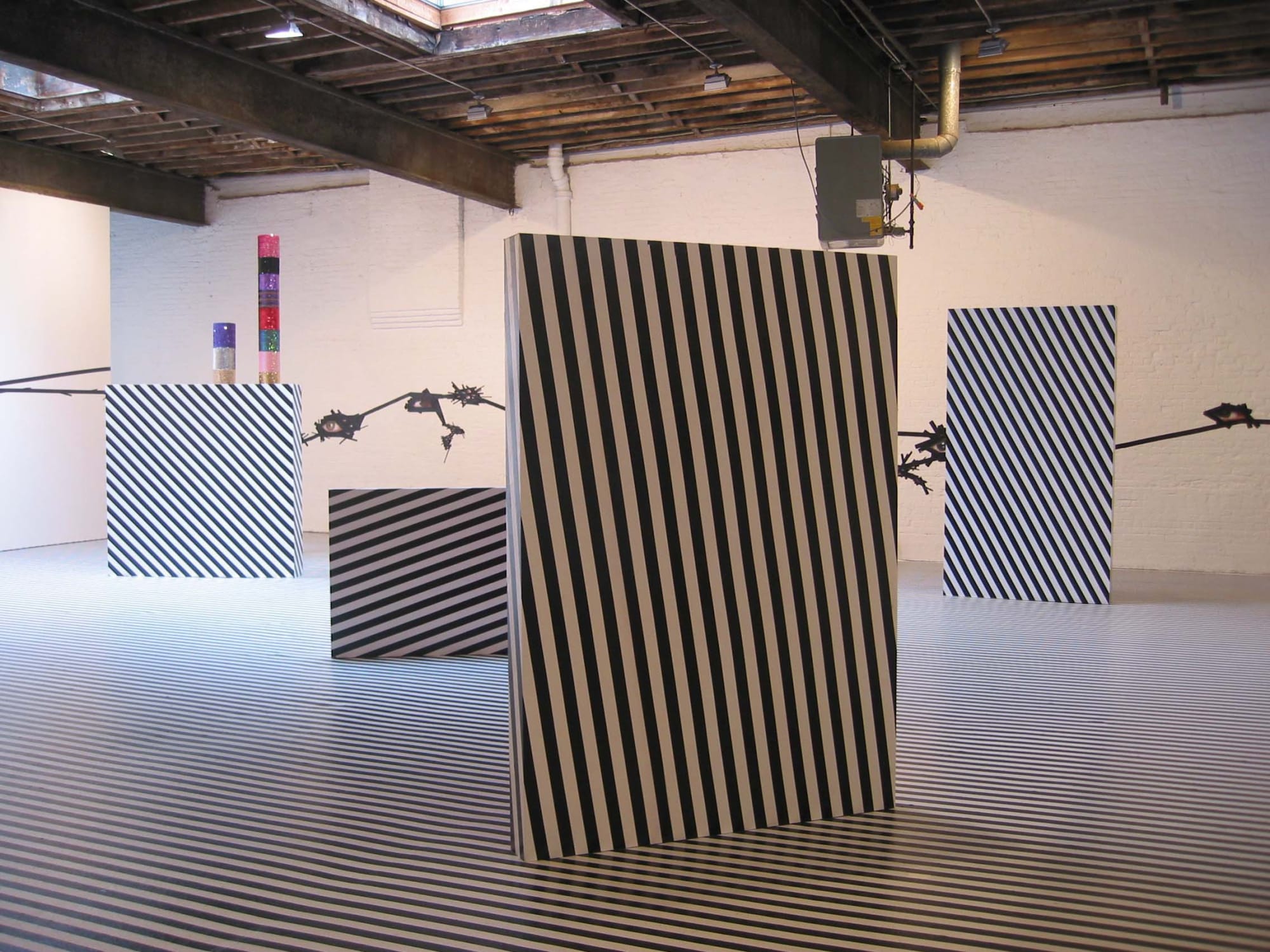 Installation view of Jim Lambie's show titled Mental Oyster. The back of some sculptures.