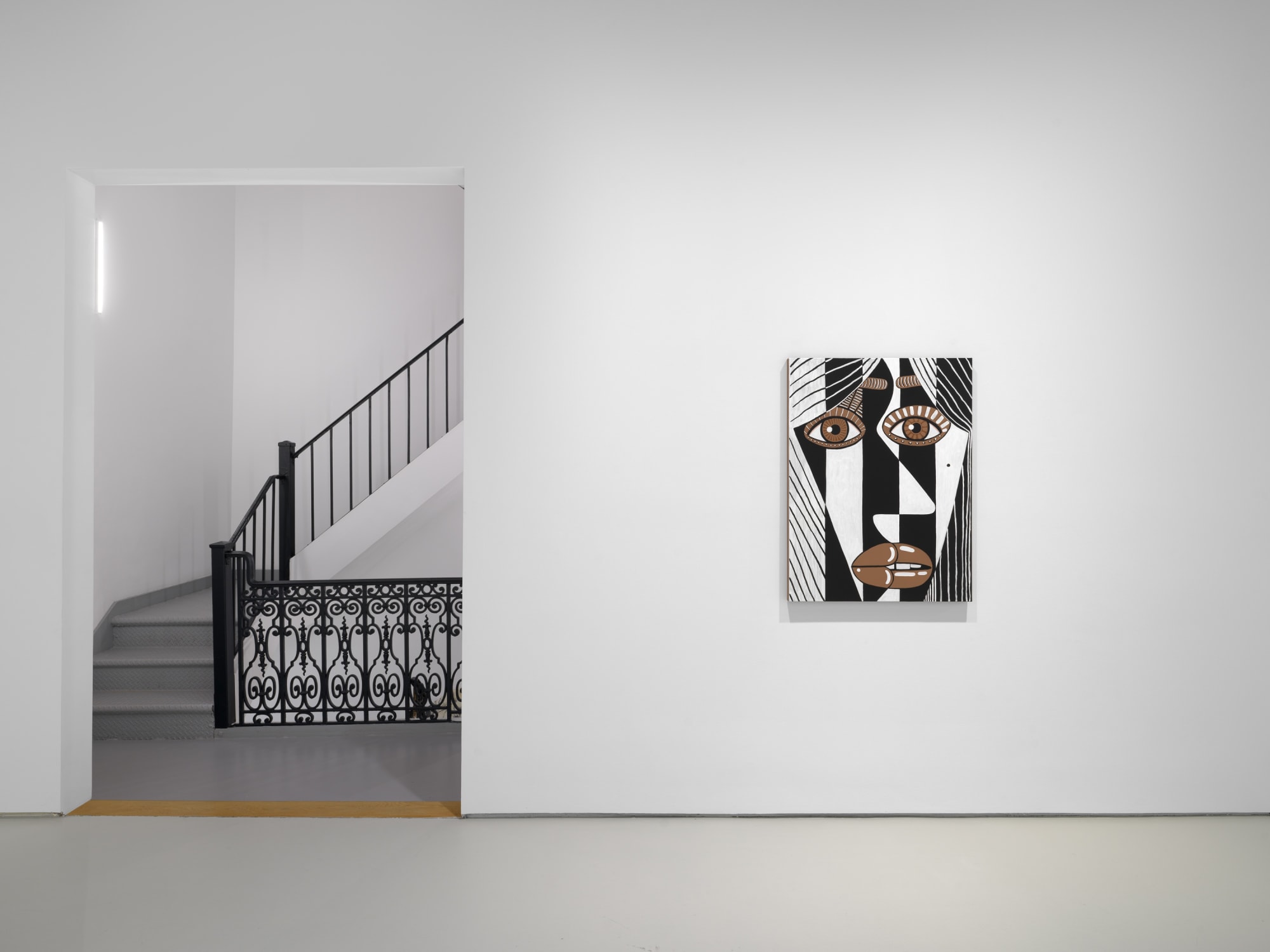 installation view of Brian Calvin's Waiting featuring paintings with hyperbolic color, mosaic eyes, and more. This image displays "Edmeshed" one of Calvin's few paintings that refrain from graphic color.