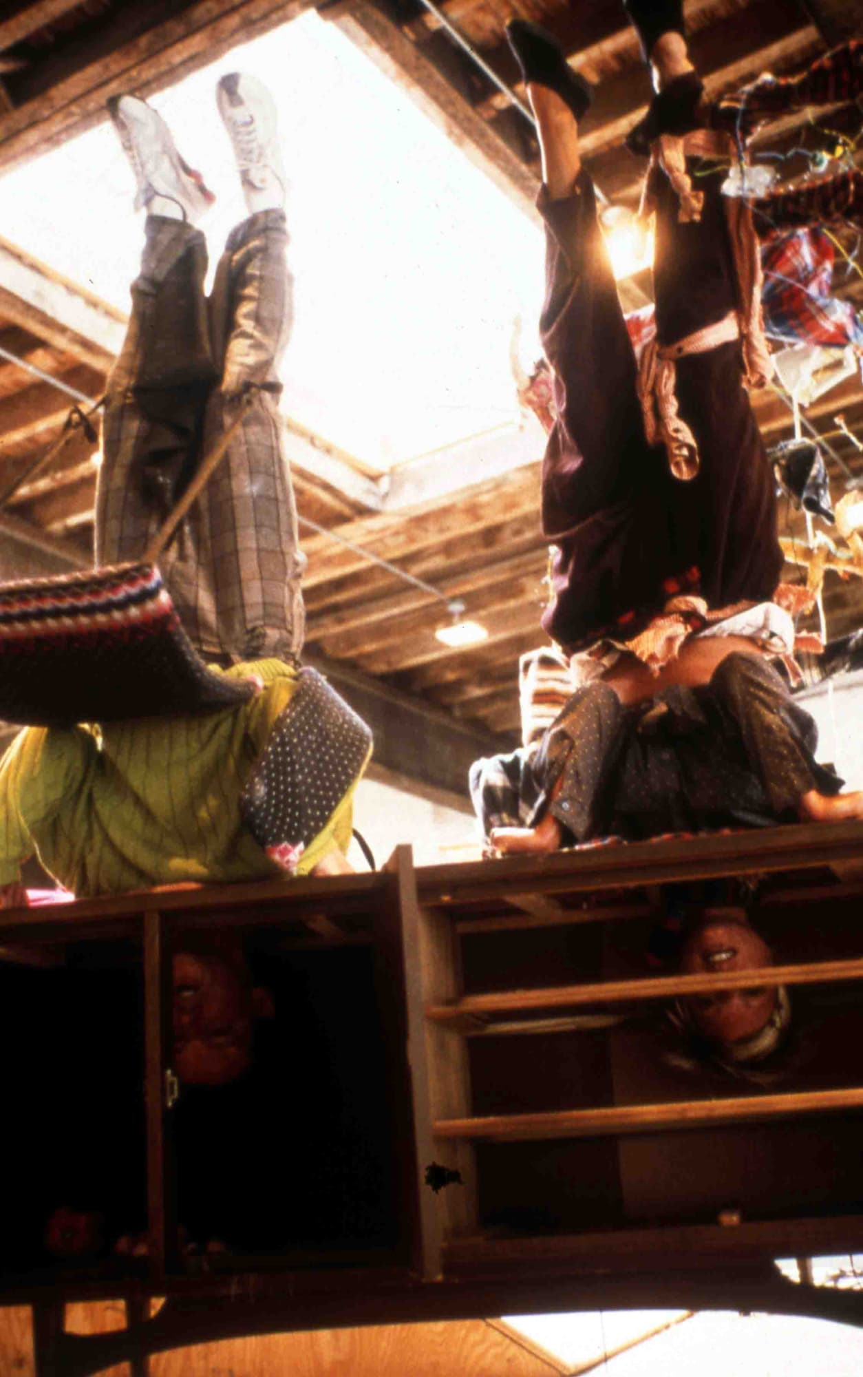 Installation view of John Bock's solo show, a social sculpture including lectures, costumes, performances, a goat, and odd sculptures. People hang upside down as part of the performance.