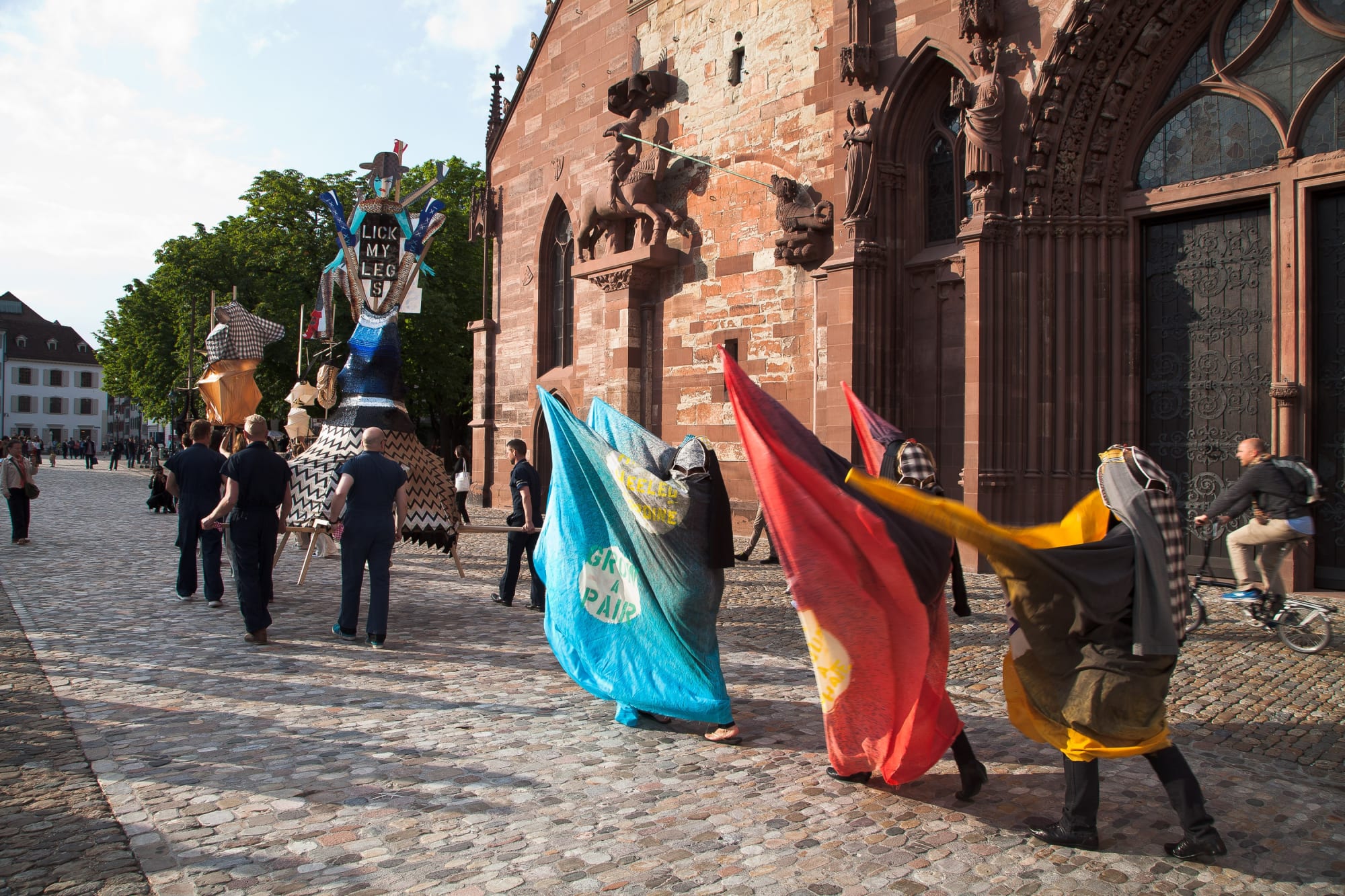 Installation view of Lara Schnitger's show at Basel Parcours, featuring a large body of works as well as a procession through Mezzeplatz. Schnitger's works hung around marchers in the procession.