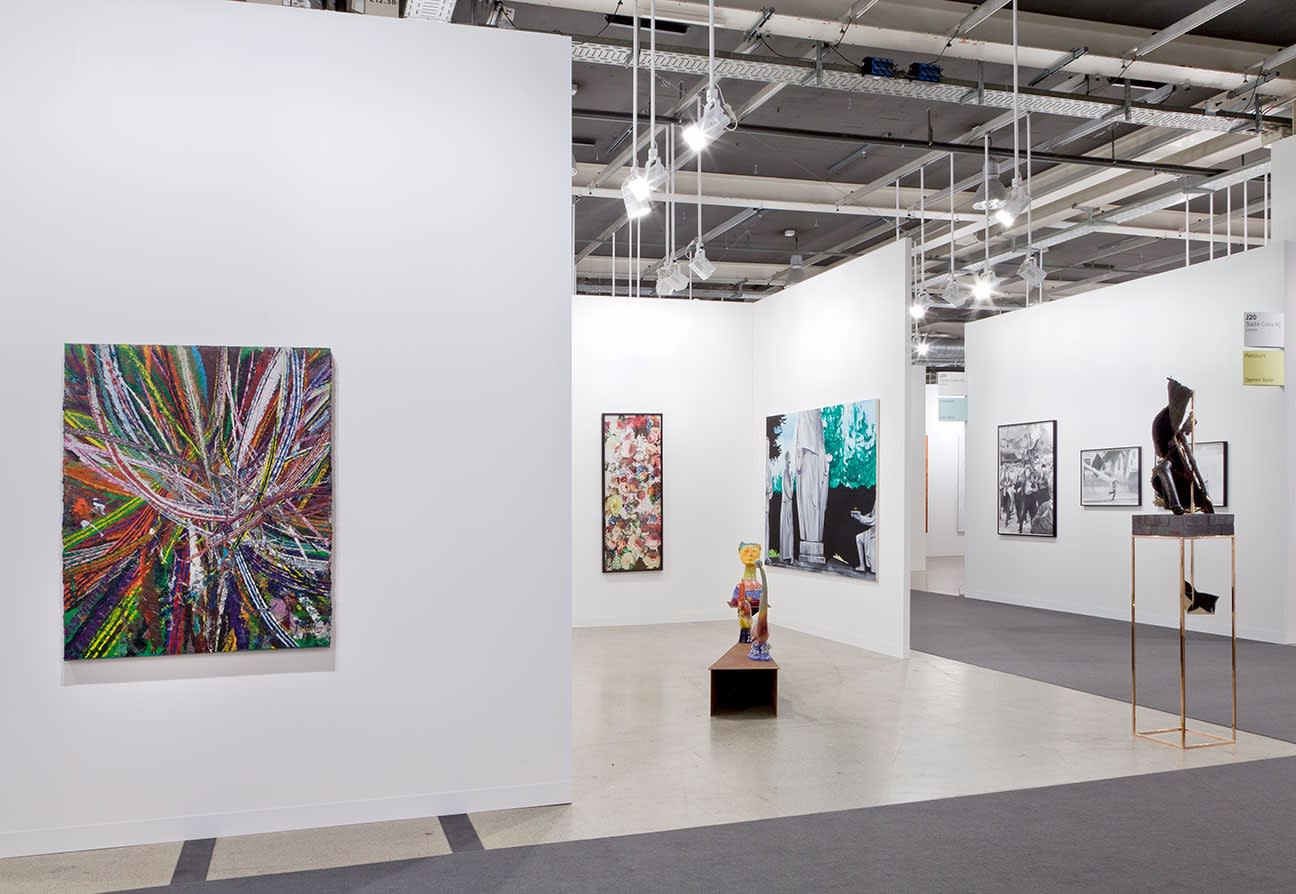 Installation view of Anton Kern Gallery's booth at Basel 2014. Mark Grotjahn's characteristic geometric lines grace the exterior, a Monahan sculpture and Sasnal piece also featured.