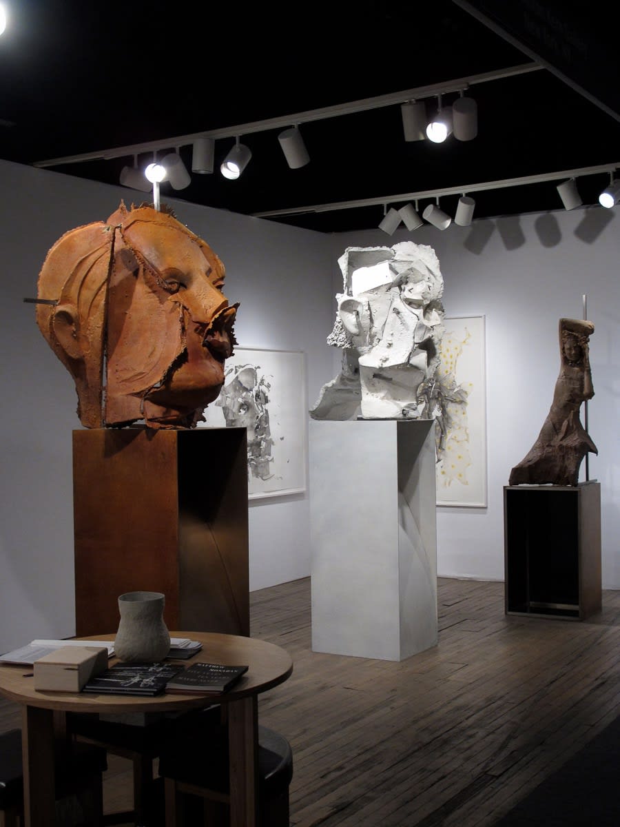 Installation view of the Anton Kern booth at ADAA 2012, featuring a solo show from Matthew Monahan. Side angle of Monahan's battered faces.