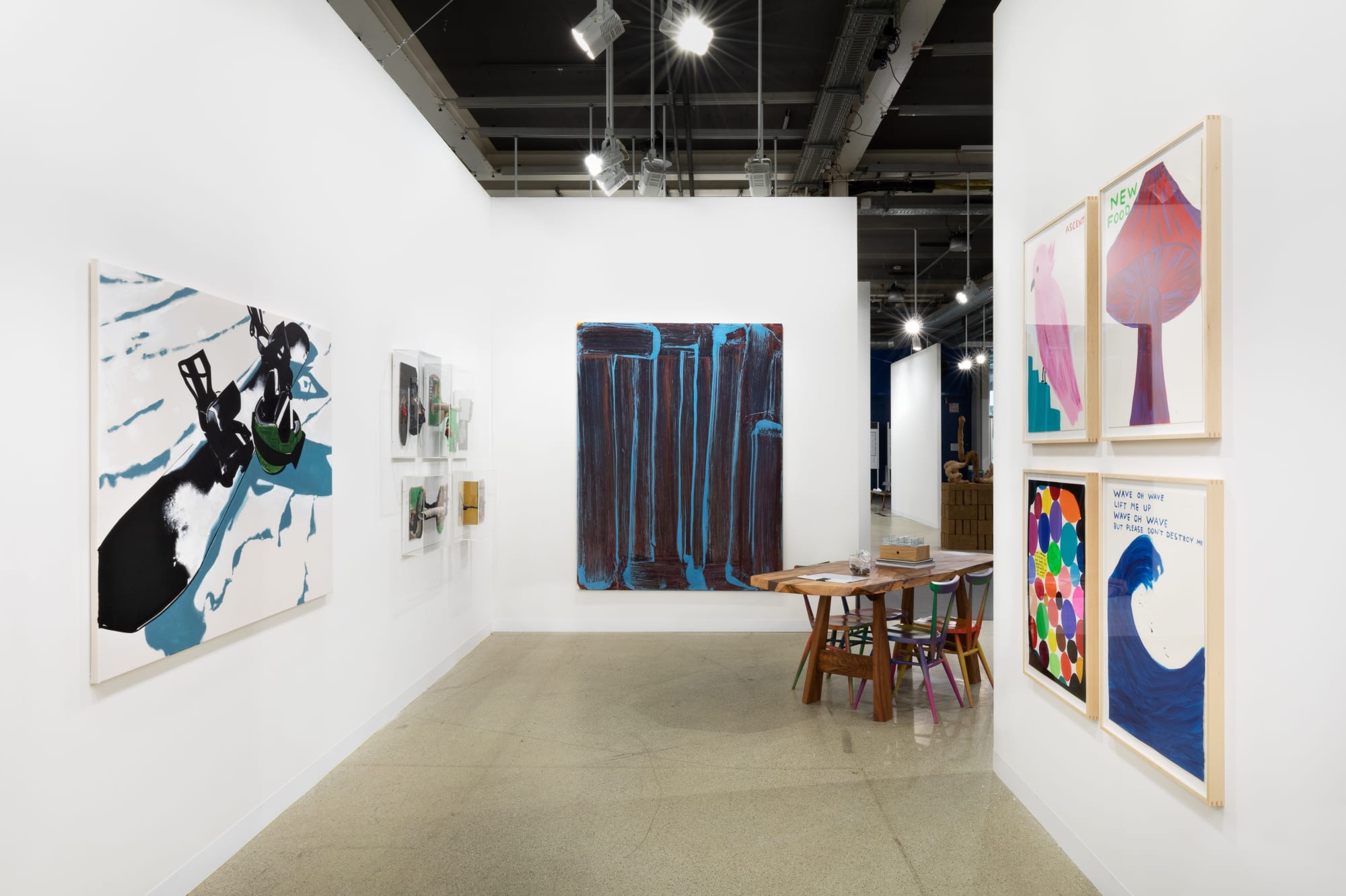 Installation view of Art Basel featuring a blue painting by Richard Janitz on back walll.