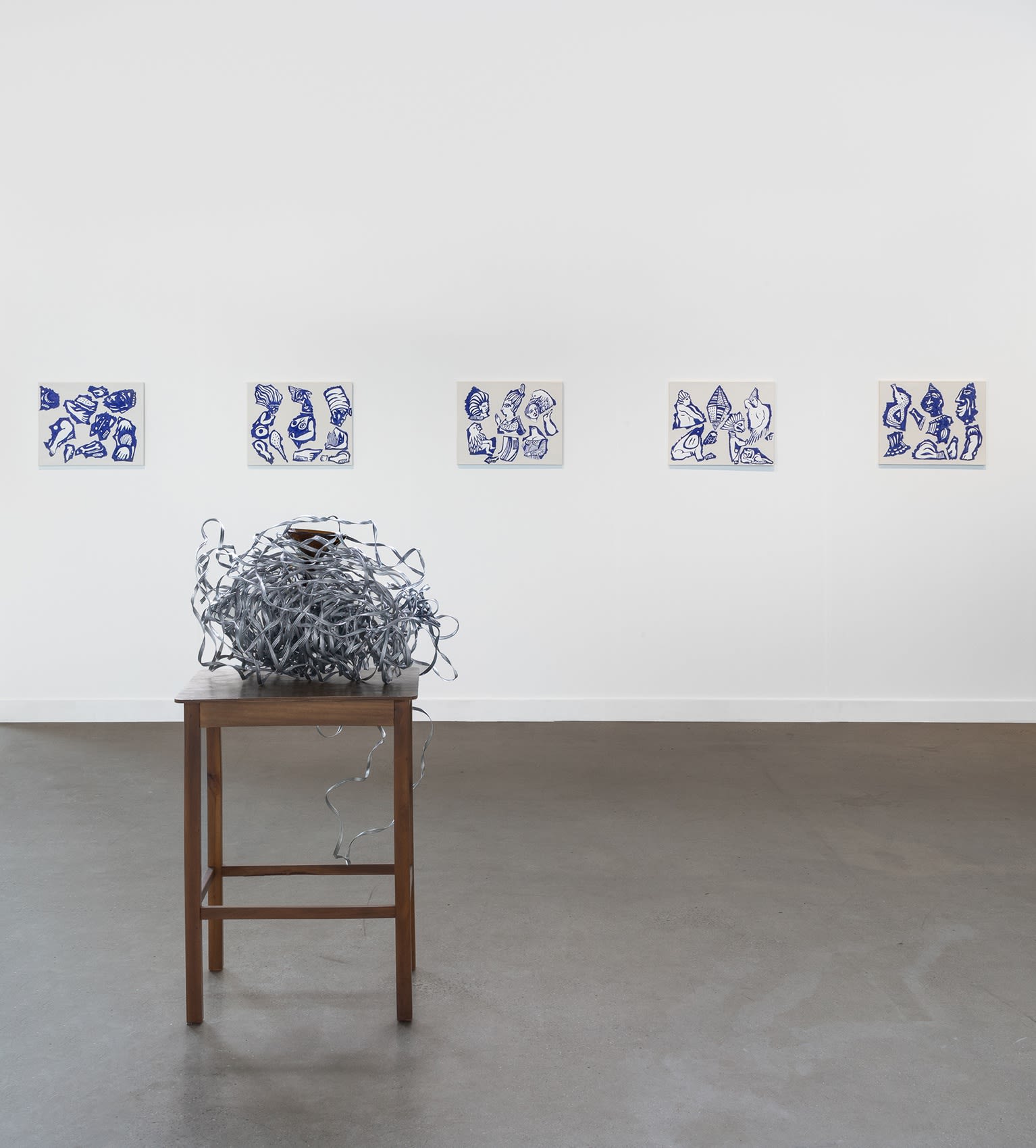 Installation view of dual booth featuring Julie Curtiss and Marepe. Julie's work is primarily paintings and Marepe's are the sculptures in the center.