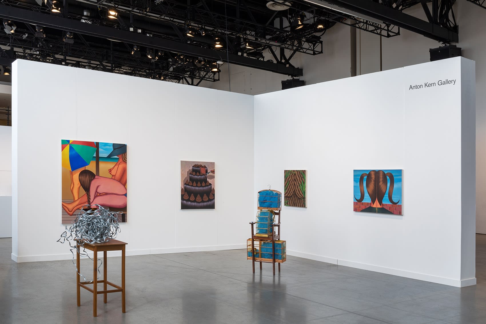 Installation view of dual booth featuring Julie Curtiss and Marepe. Julie's work is primarily paintings and Marepe's are the sculptures in the center.
