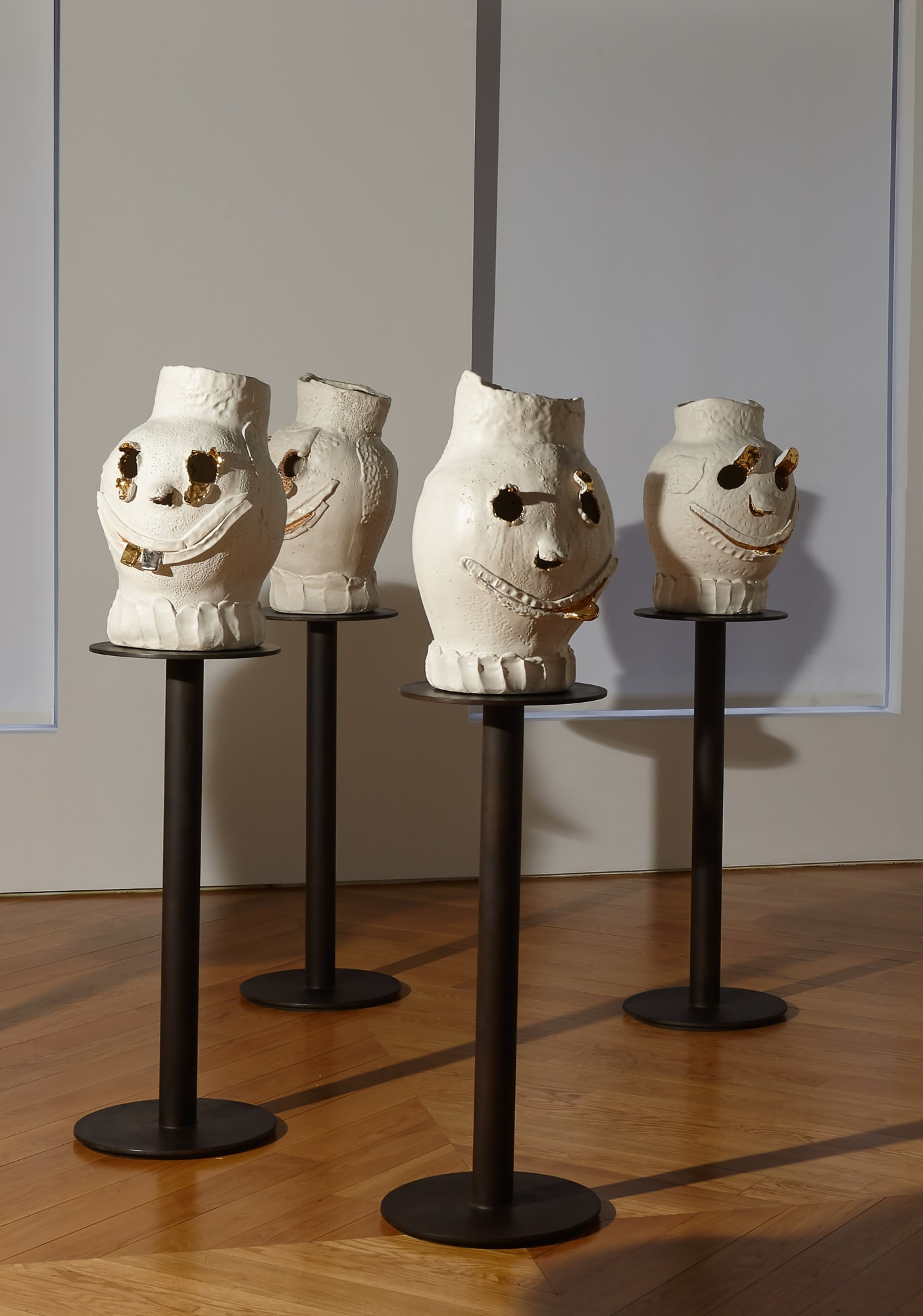 Installation view of Dan McCarthy's exhibition '7 Bangers', a group of seven ceramic sculptures with faces. Four of Dan's faces featured.