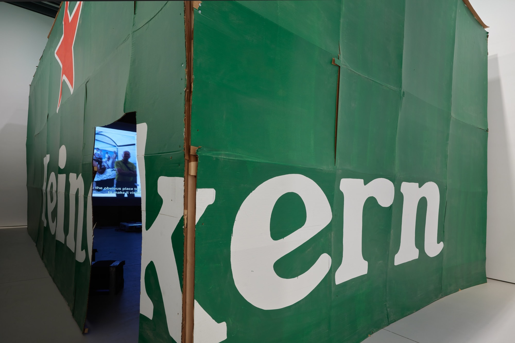 Installation view of Erik van Lieshout's exhibition at the gallery 'BEER' -- featuring an immersive Heineken installation and new collages. A look at the Heineken wall.