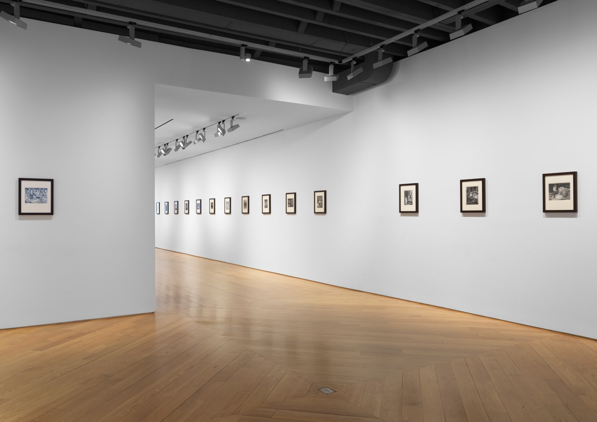 Installation view of vintage Weegee photos. Many small works shown.