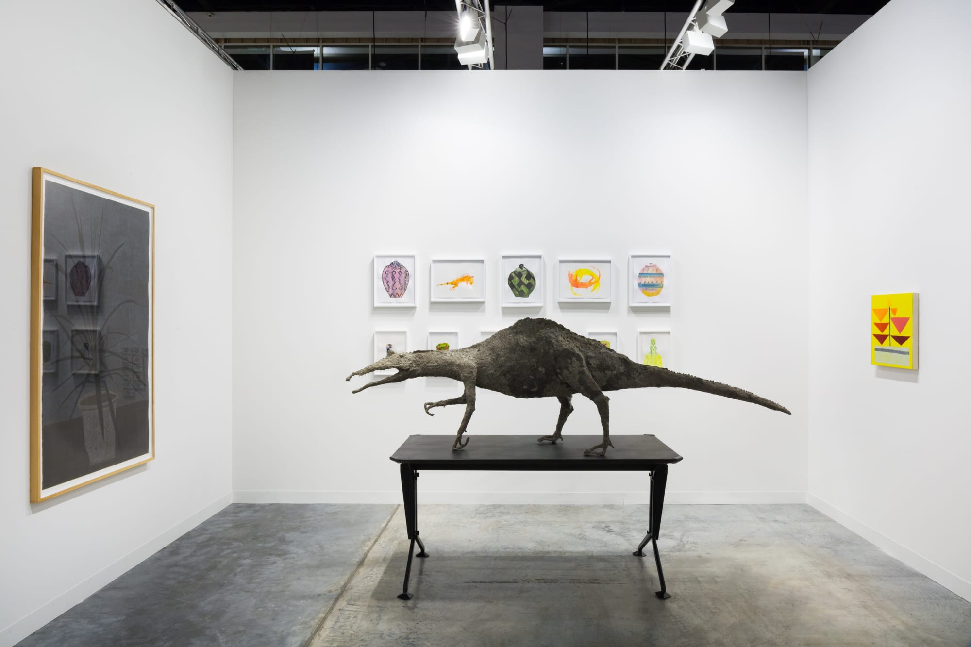 Installation views at Art Basel Miami Beach featuring paintings, sculptures, and more. Walls are white and works of art are colorful.