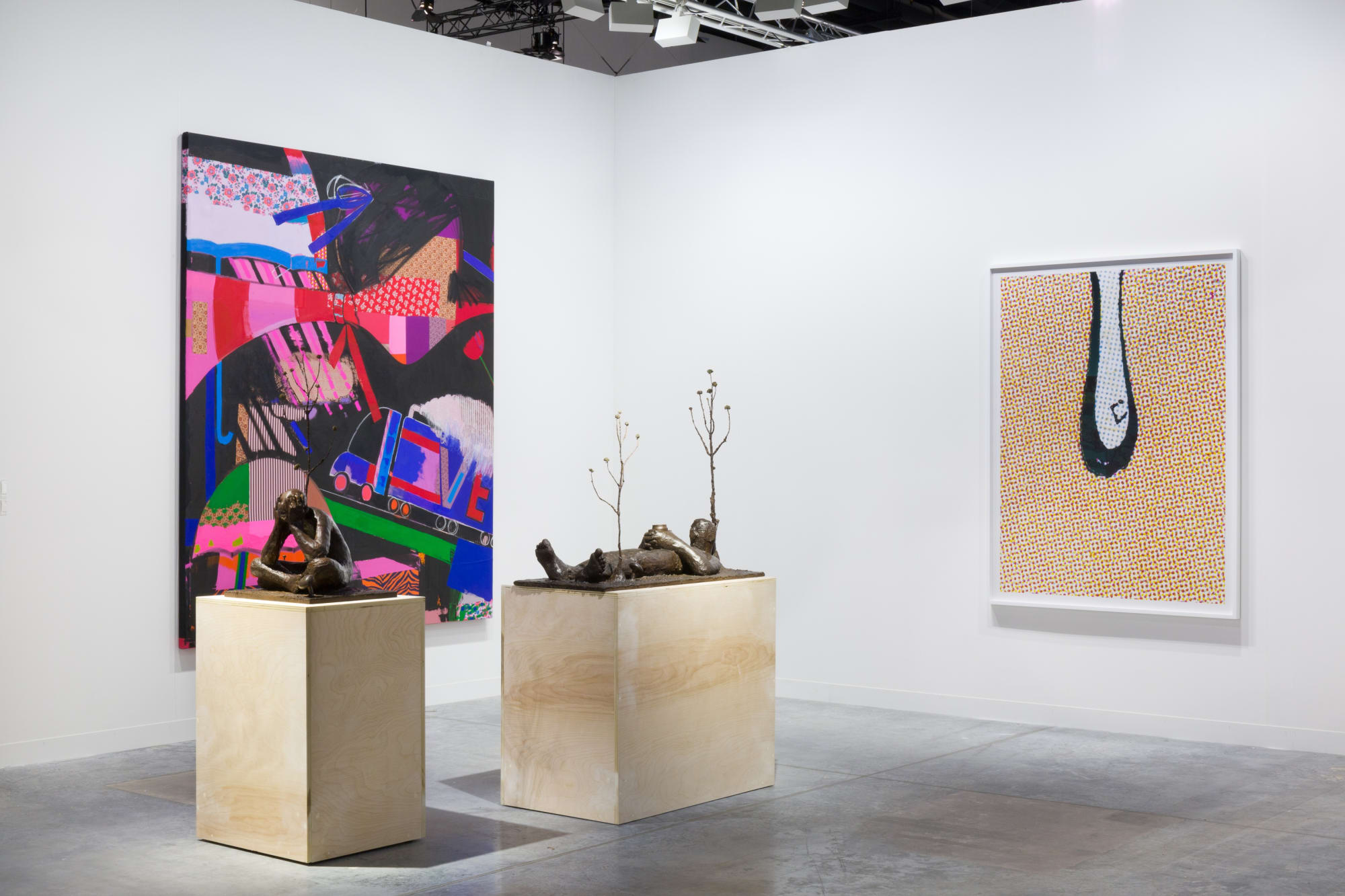 Installation views at Art Basel Miami Beach featuring paintings, sculptures, and more. Walls are white and works of art are colorful.