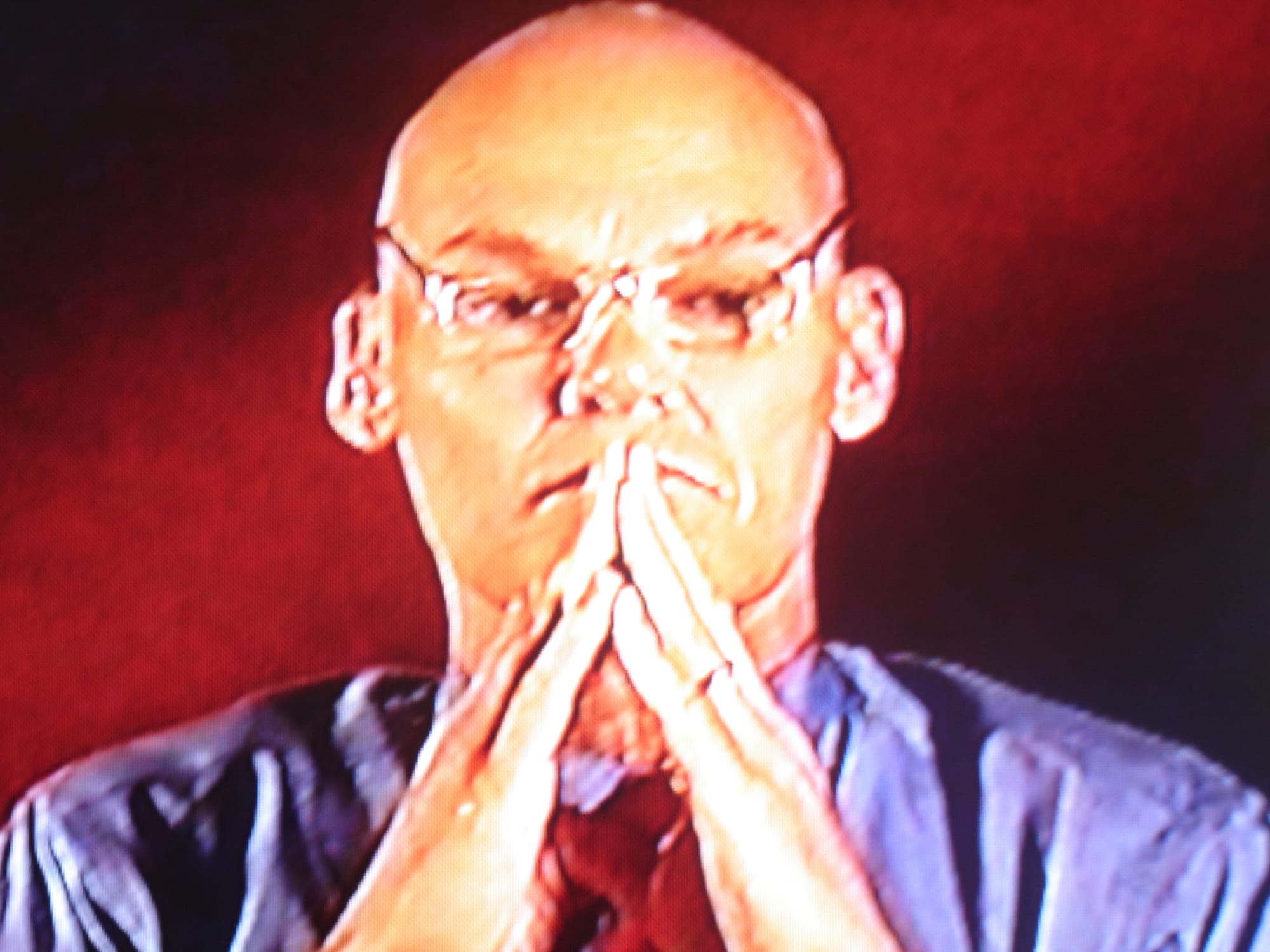 Screenshot of James Carville with his hands in prayer position pressed against his face