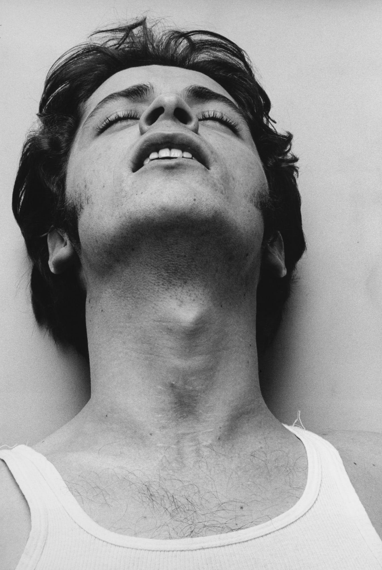 Black and white photograph of man with his eyes closed and head leaned back