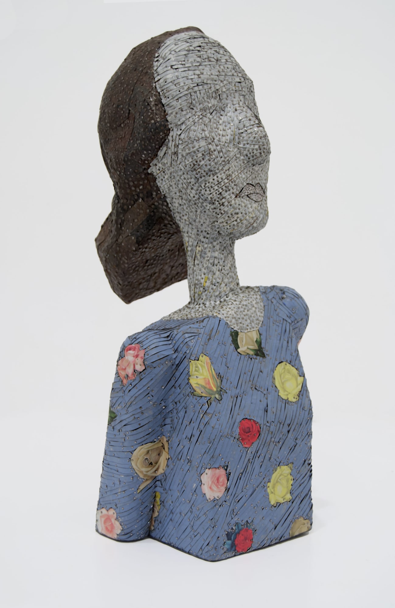 Three-quarter view of the bust of a woman made from ceiling tin