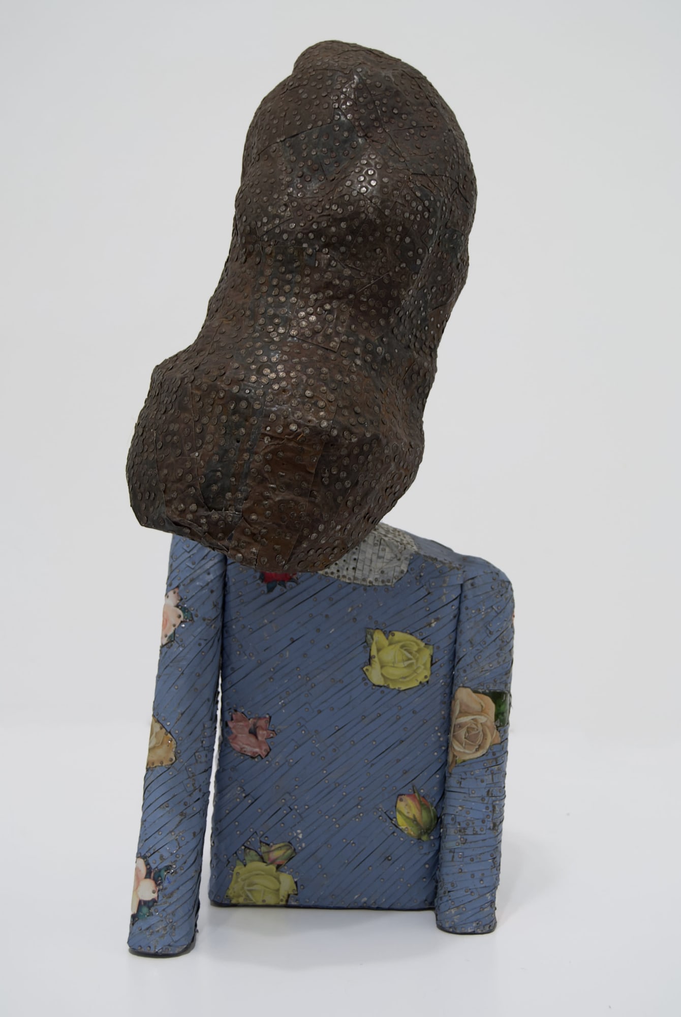 Back view of the bust of a woman made from ceiling tin