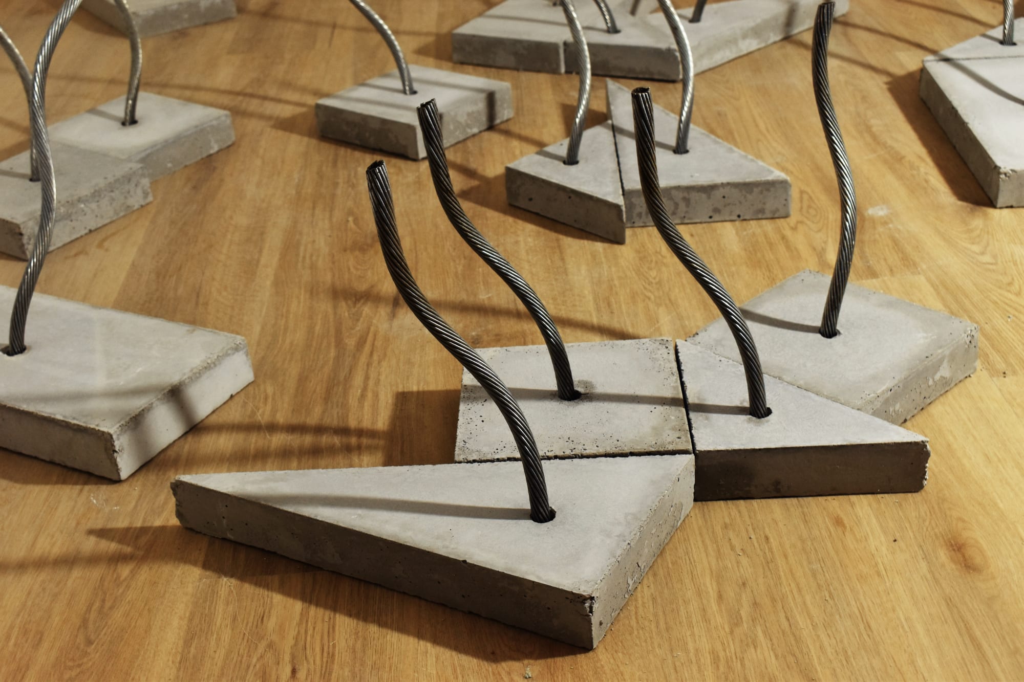 A detail shot of several sculptures made of wire rope embedded into concrete bases showing how they can be arranged 