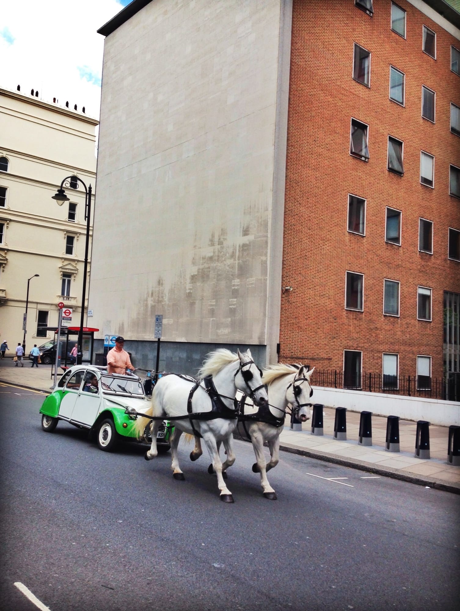 Deux Chevaux Performance piece, man riding a horses attached to a green car