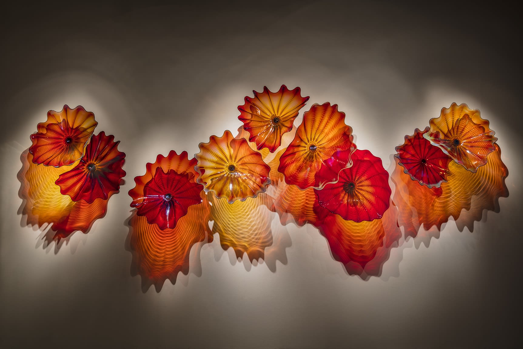 Dale Chihuly, Copper Ruby Persian Wall, 2018, 5 x 15 1/2 x 2 feet © 2023 Chihuly Studio. All Rights Reserved.
