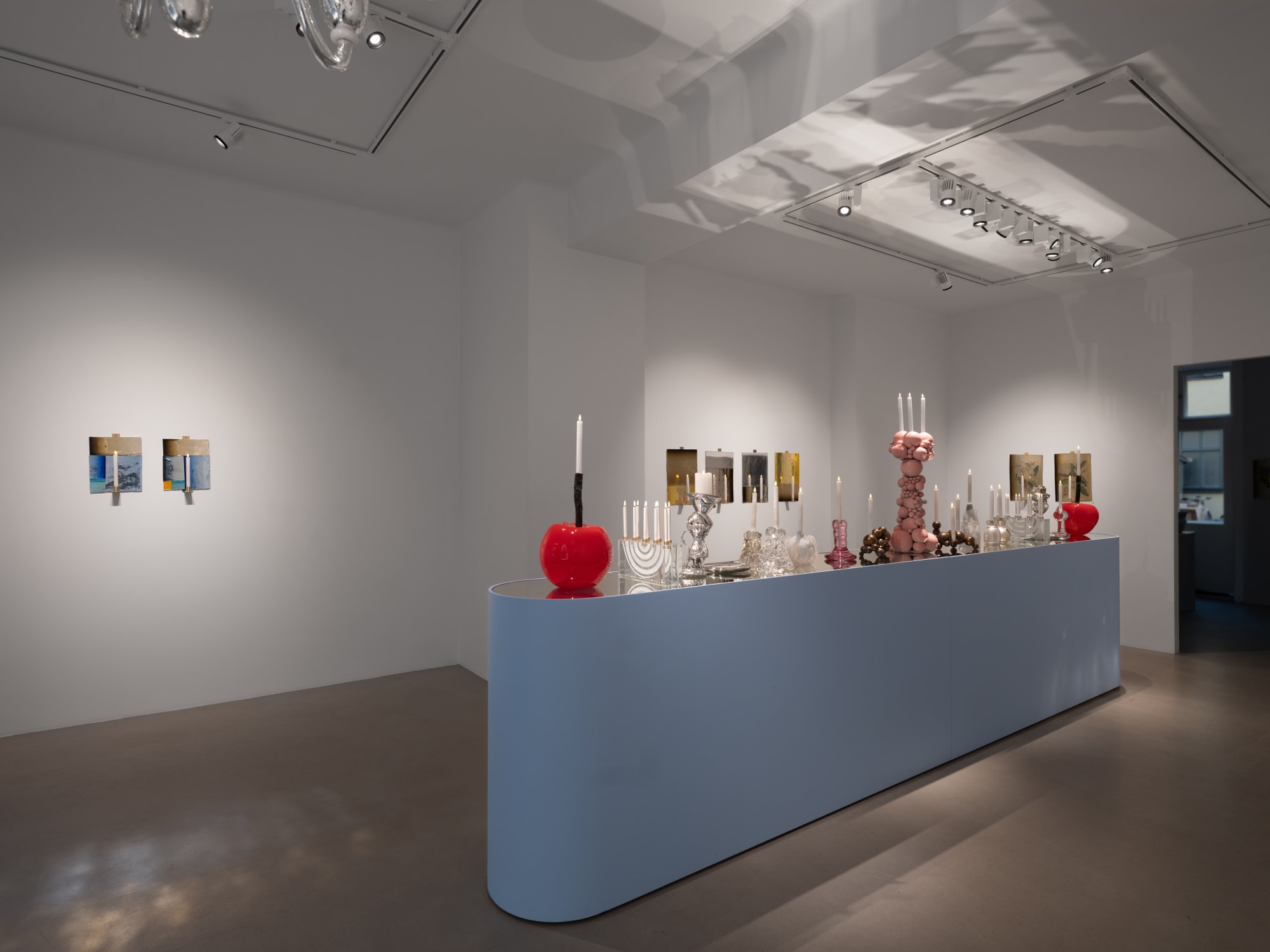 utställningen ljusbord med blått podium och levande ljus. många ljusstakar på rad. Rött stort körsbär