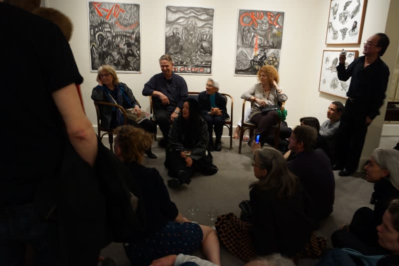 Photograph of artist Sue Coe talking to the crowd during the opening of her exhibition "Mad as Hell," 2012