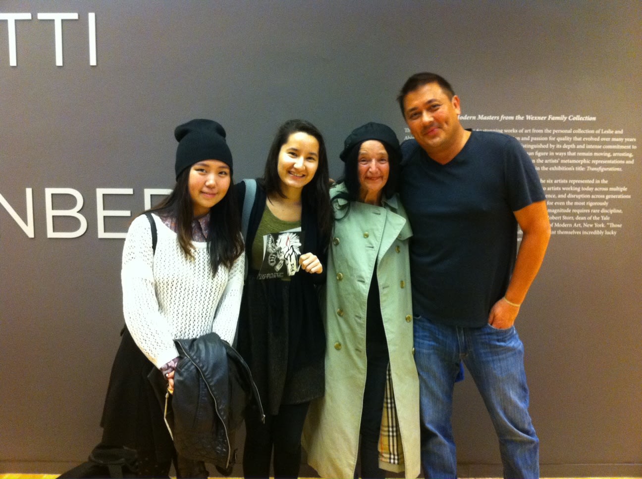The artist stands with three people in front of an a wall at Ohio State University's art gallery