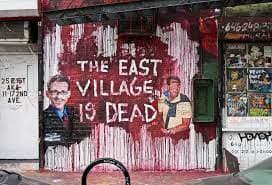 Photograph of a mural on a building that reads "The East Village is Dead"