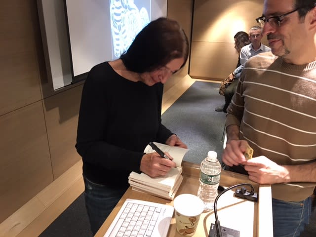 The artist signs a book for a waiting fan, Kendall College of Art and Design, 2017