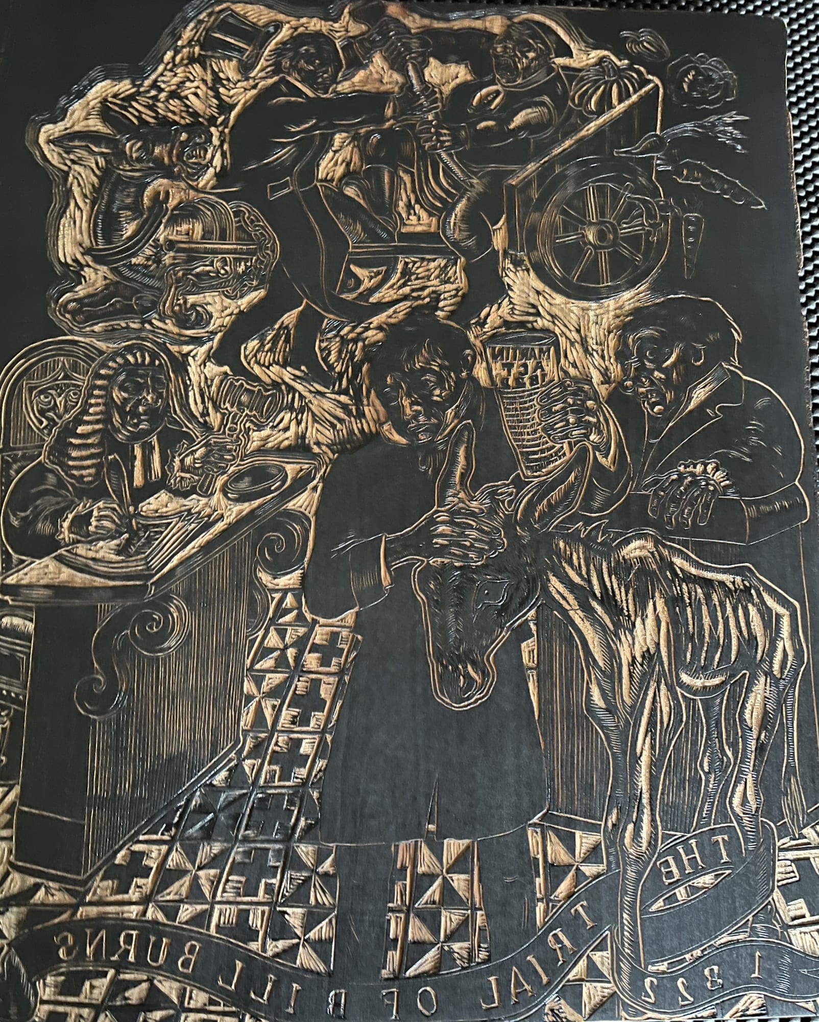 In process carving on a wood block showing a lawyer representing a man with a horse in front of a judge. 