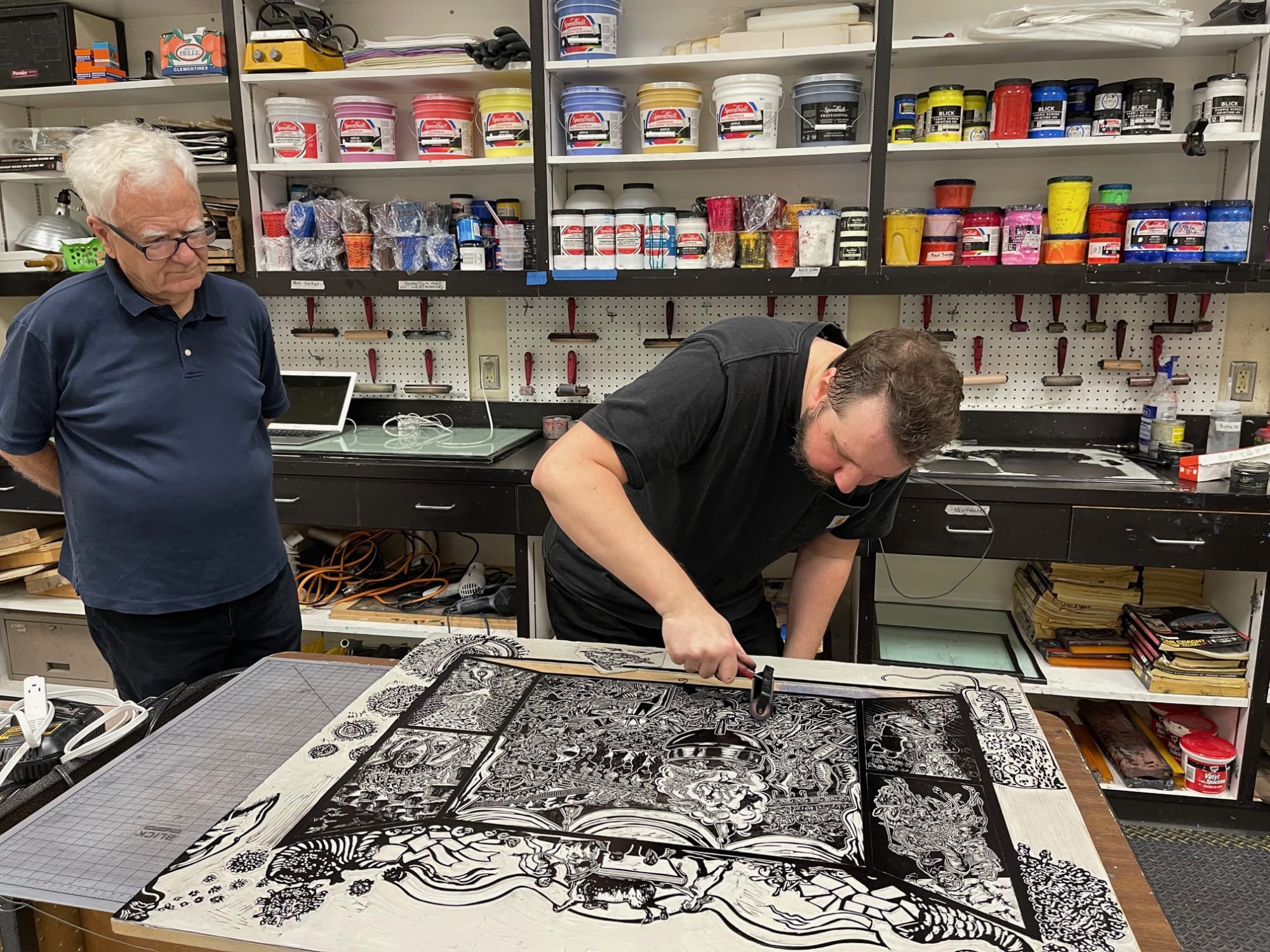 Master printer Jesse Shaw works on Zoonotic Spillover while Dr. Eric Avery looks on, TAMIU, Laredo, TX, 2023