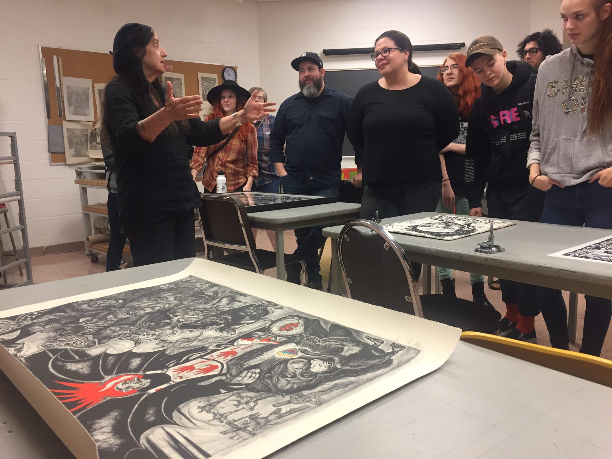 A picture of three student printers at TAMIU help create impressions of the Sue Coe print "Zoonotic Spillover."