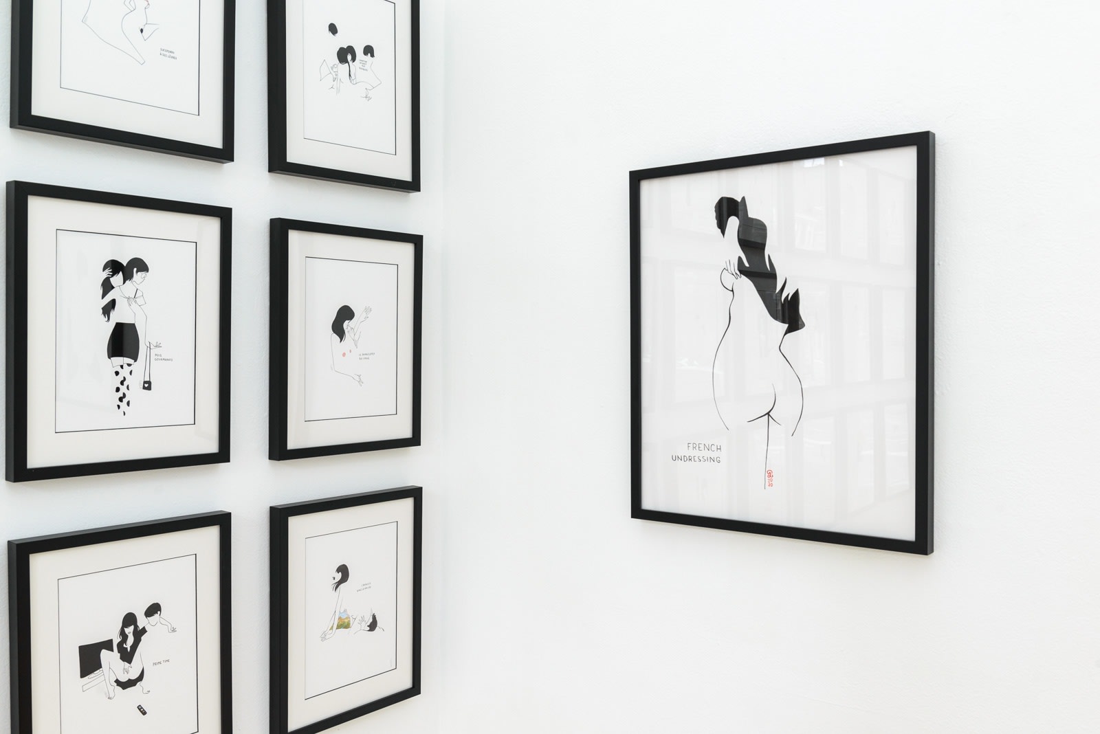 Install photo of framed illustrations by Petite Luxures hung on a wall