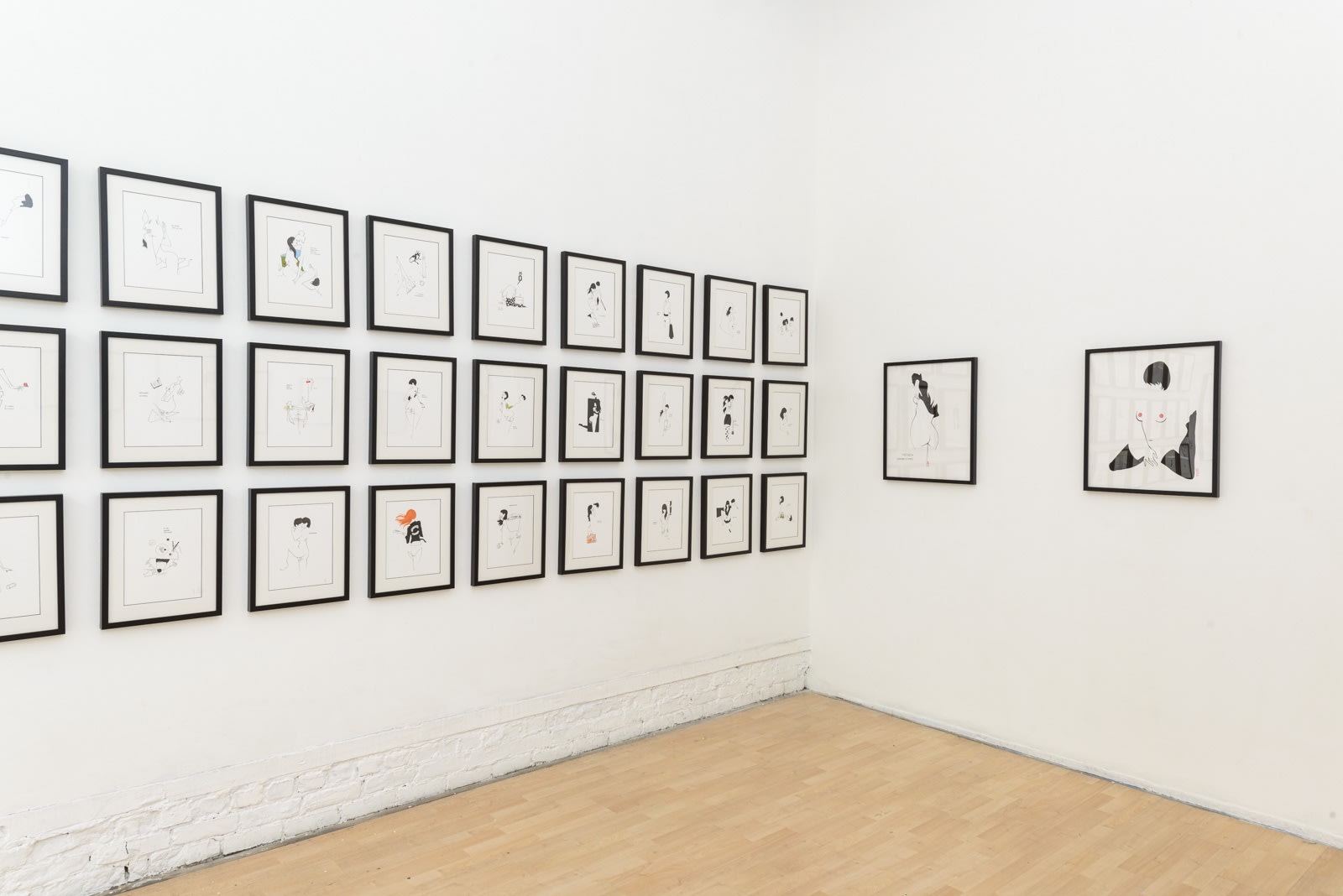 Install photo of framed illustrations by Petite Luxures hung on a wall