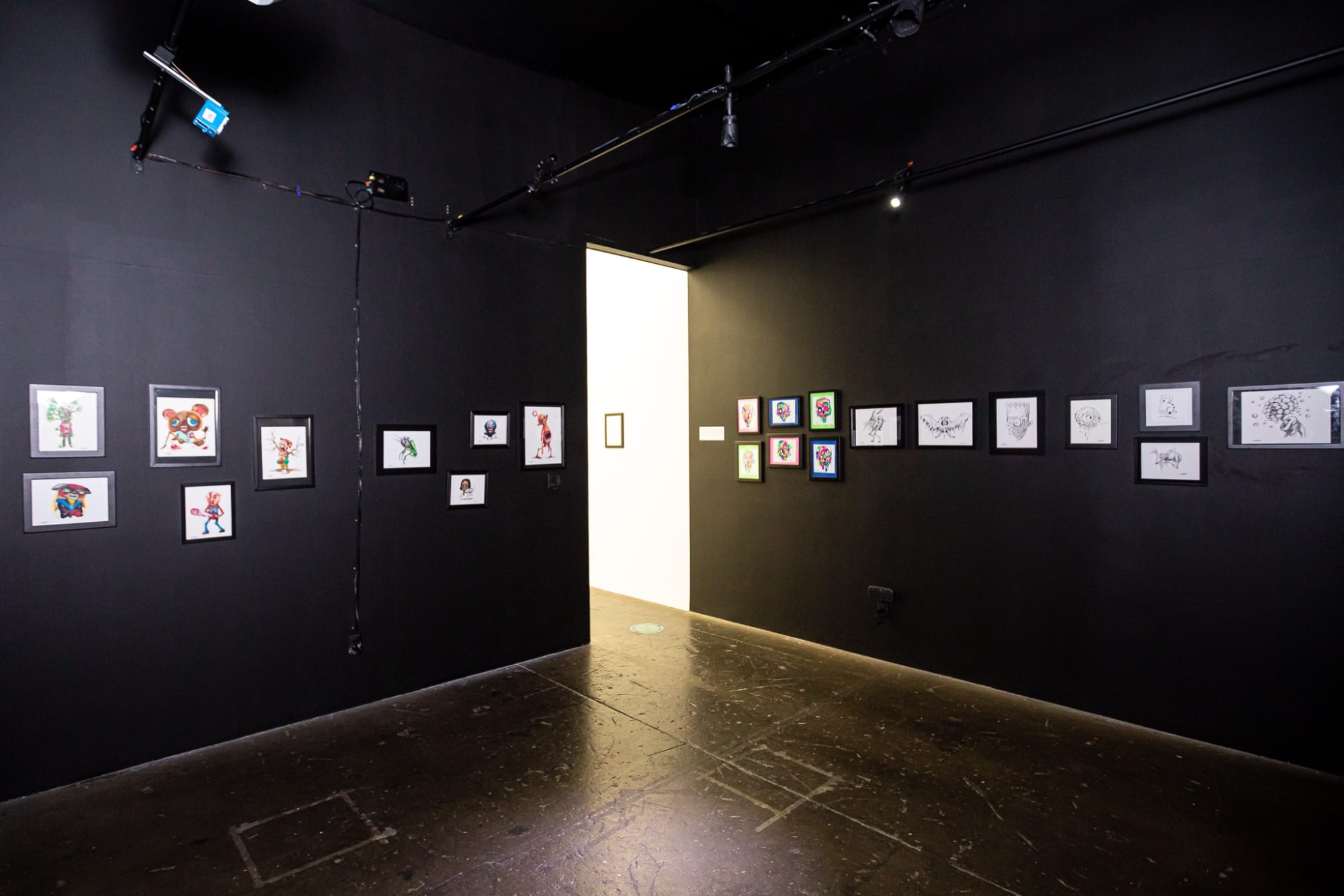 works by Alex Pardee hung on black walls