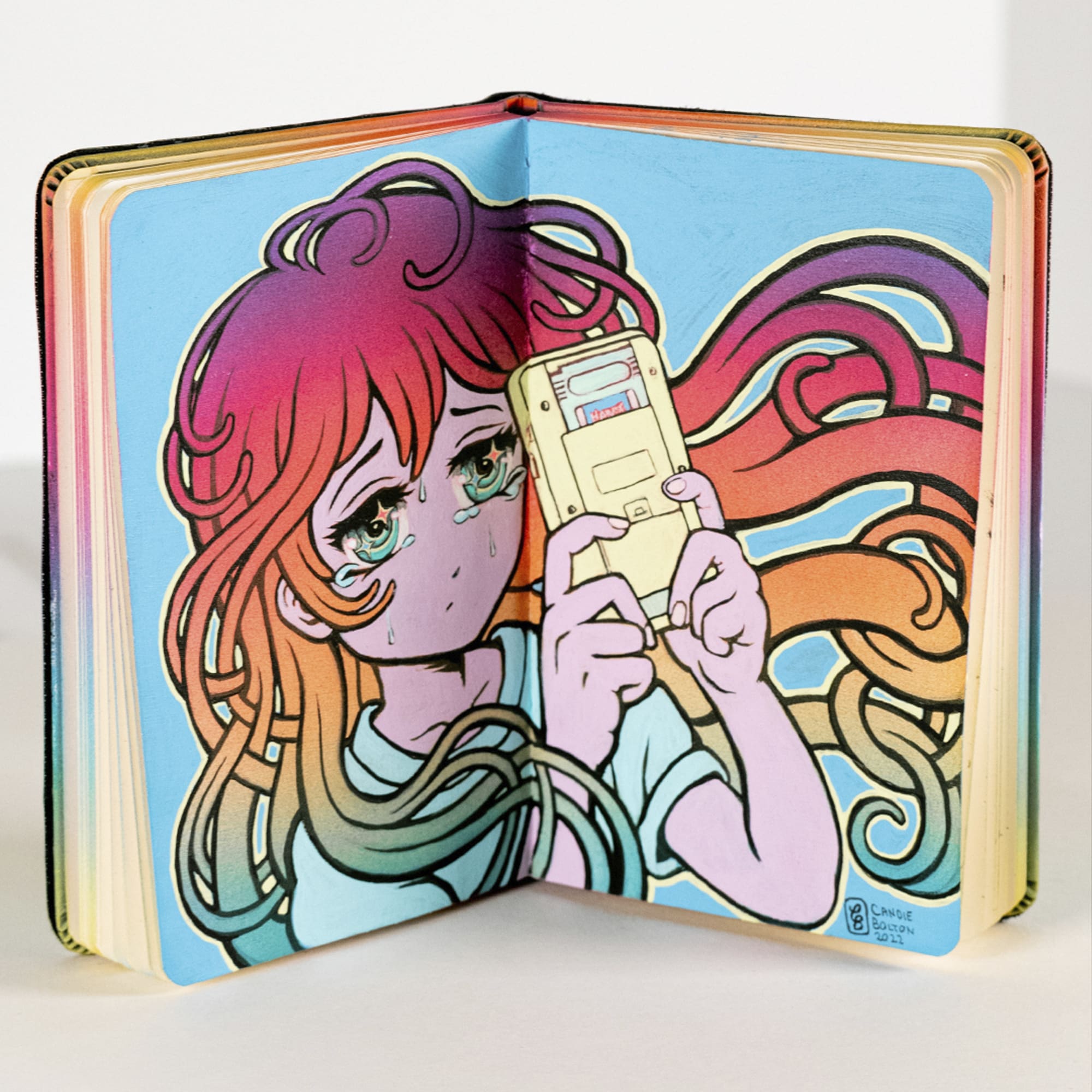 moleskin notebook with a drawing of a woman with colorful hair looking at a phone 
