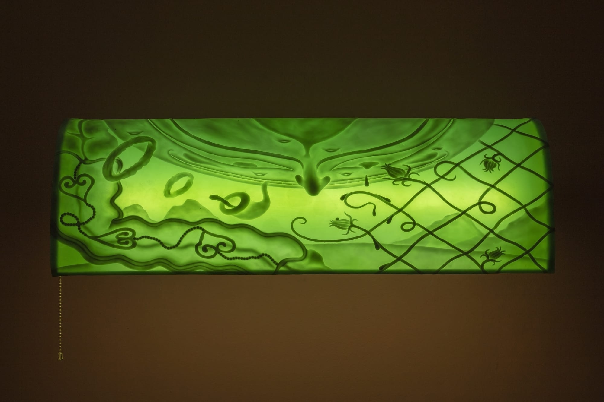 ASMA Tallos entretejidos con tiernos retoños desprendían un batiburrillo de perfumes. Su cara estallada de luz en la abismal planicie que sostiene los astros se regocijaba con una sonrisa extendida y grotesca cuando veía las caras pálidas engullendo sus propios corazones, 2023 Silicone, brass, fluorescent light bulb, electrical hardware, acrylic. 18 x 61.3 x 33.3 cm (7.08 x 24.13 x 13.11 in)