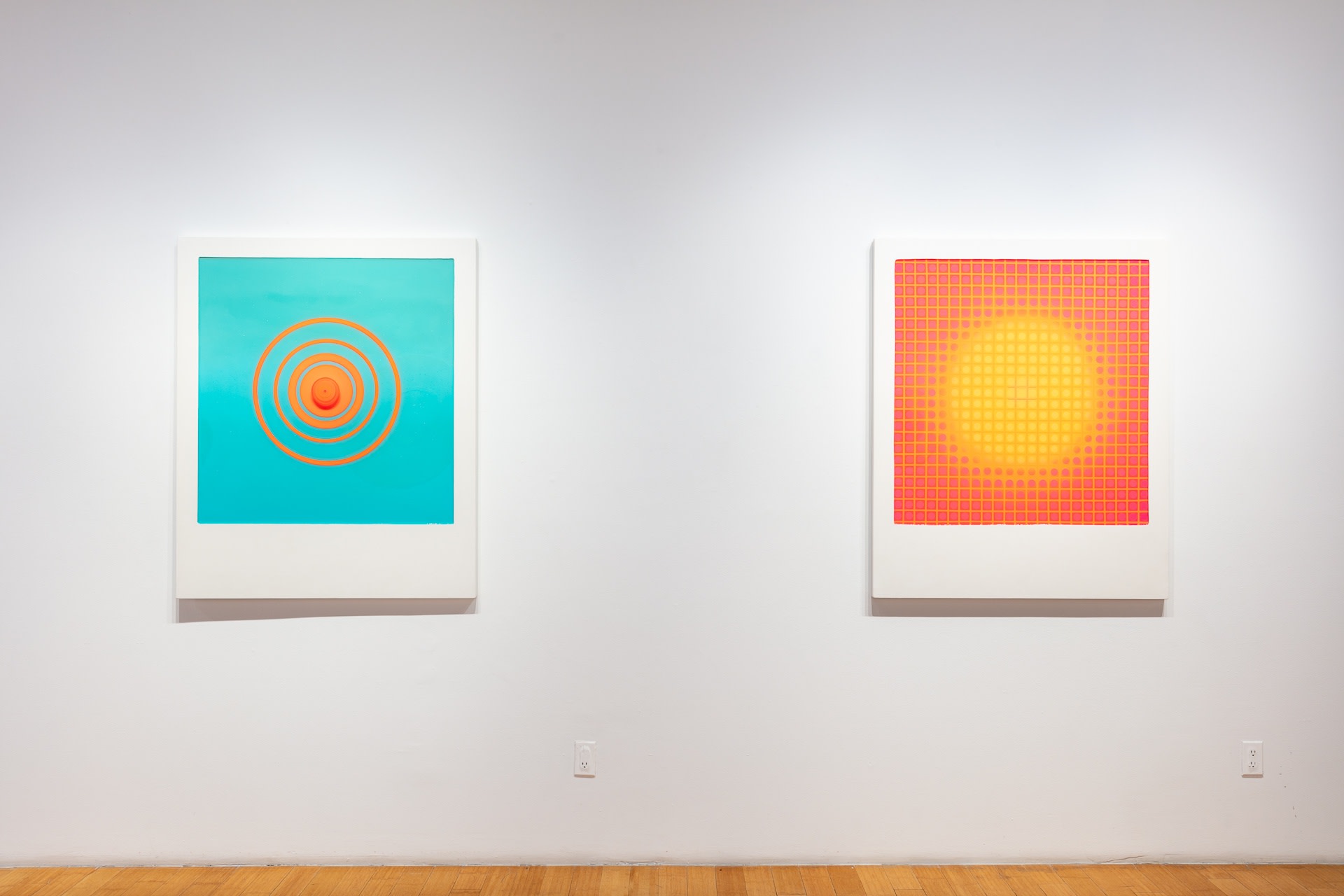 Close up installation shot of Future Maybe showing Anon 8 and 5, two large wall sculptures with a form mimicking a Polaroid. Their Polaroid frames are made of white wood panels and the place where the images would be are filled with colorful resin.