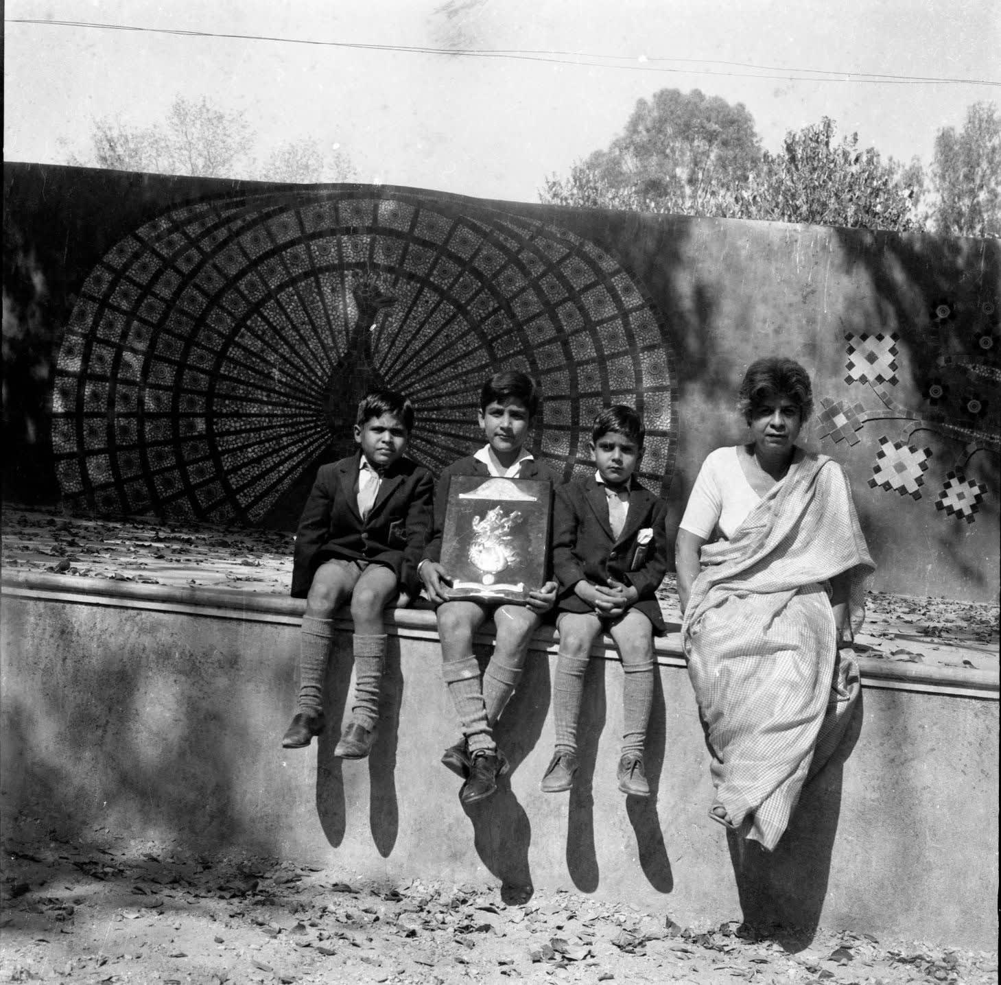 Leela Mukherjee with her students in Dehradun, in front of her tile mural.