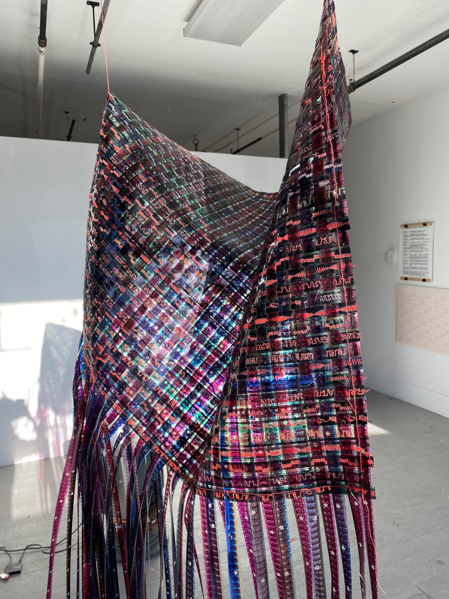 Agustina Markez Desde Lejos Weaving, 2021 16mm film strips, decorative stitches with red thread 36 x 24 in.