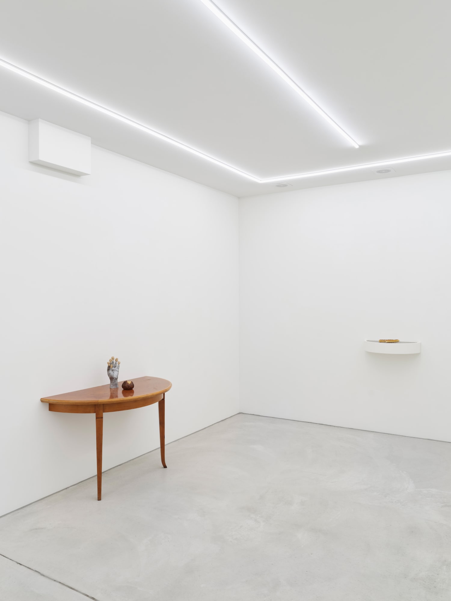 Left, Seem Less, 2024, lime wood, aluminum, half of a table, faux bread roll, beeswax, 104 × 125 × 62.5 cm, version 1/3 + 1 artist’s proof