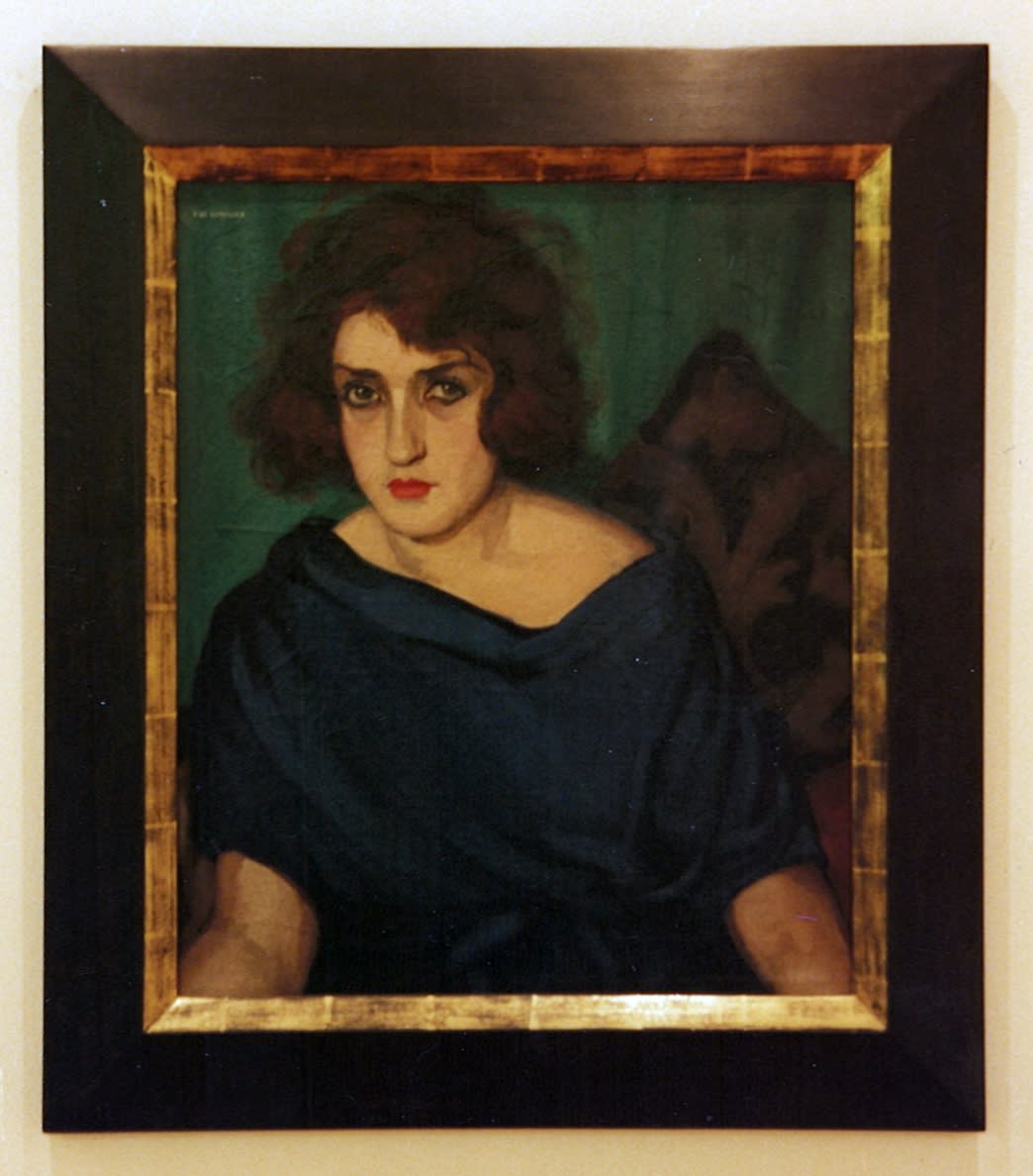 Portrait of a woman in a blue dress staring at the viewer