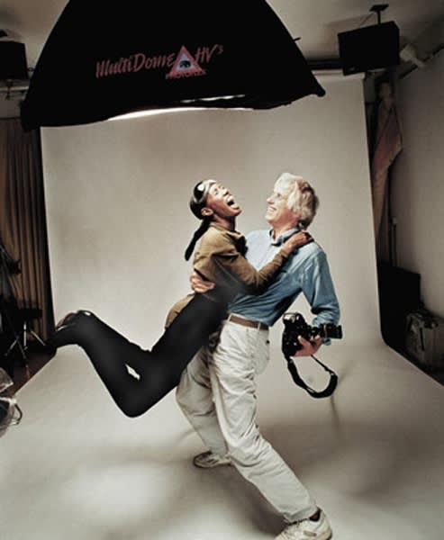 Color photograph of Douglas Kirkland lifting model Grace Jones in a photographic studio setting