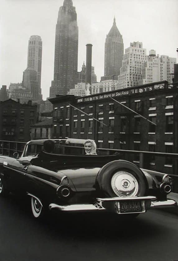 Black and white photograph of Arthur Miller and Marilyn Monroe in a Ford Thunderbird on the bridge into New York City