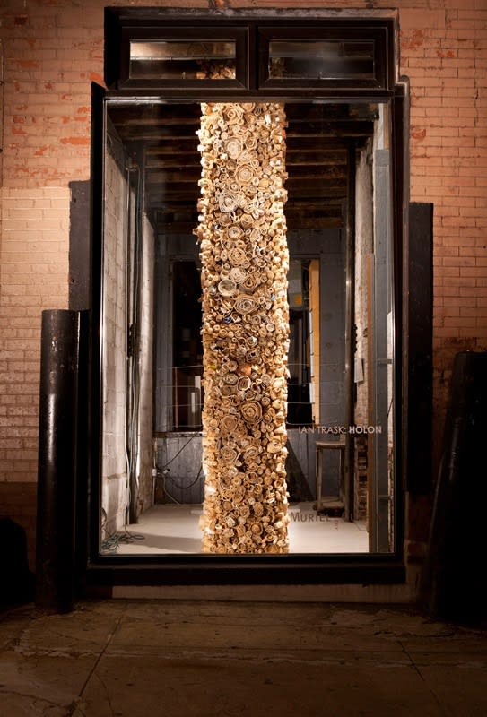 photograph of repurposed cardboard affixed to a large cylindrical piece of wood