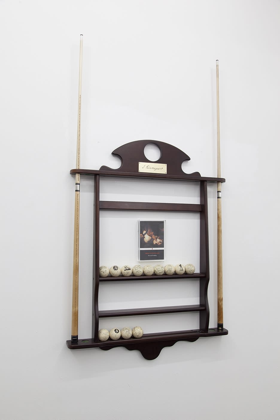 Fear and Trembling 2018 Wood, 2 laser engraved sterling cues, 16 pool balls; dye sublimation on cast polyester resin, paperback book with wallmounted plexi box Large wall rack (assembled) 59 x 37 x 7 inches Small wall rack (assembled) 59 x 27 x 3 inches Cue sticks 59 x 1 1/4 inches Balls 2 inches in diameter Paperback book 7 3/4 x 5 1/8 inches Edition 7